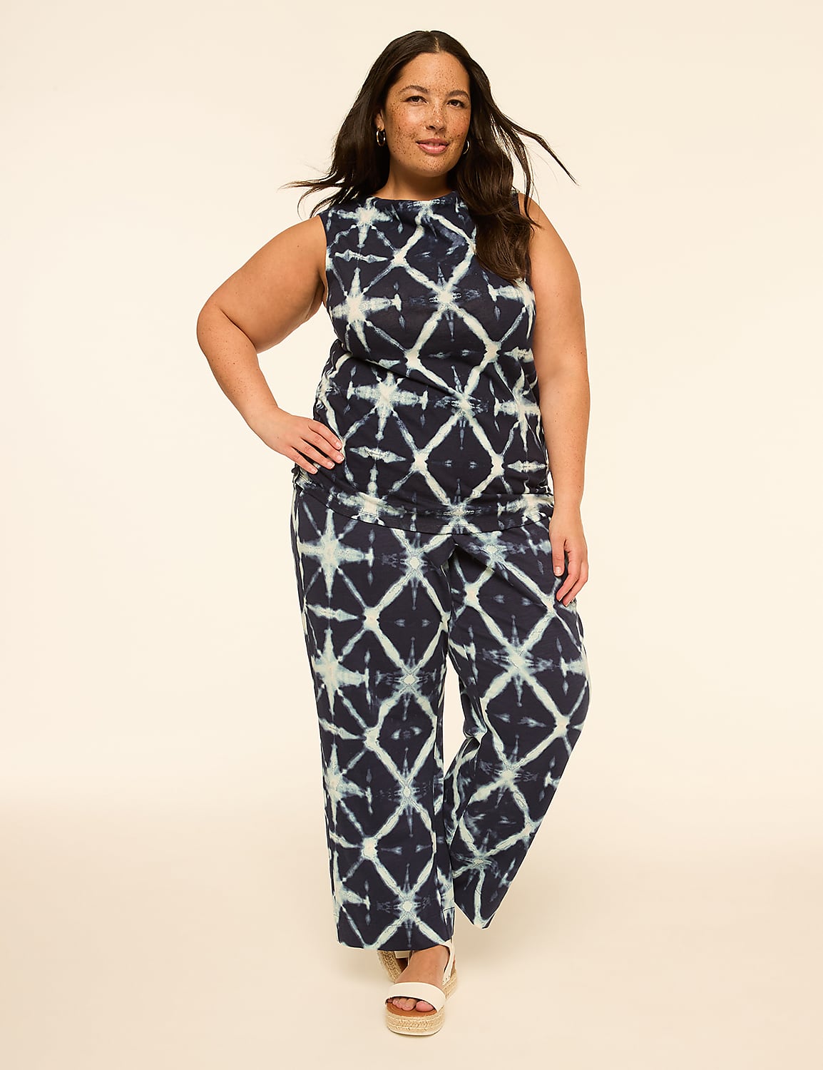 A woman in a tie-dye jumpsuit stands against a plain, light-colored background. Product Image 3