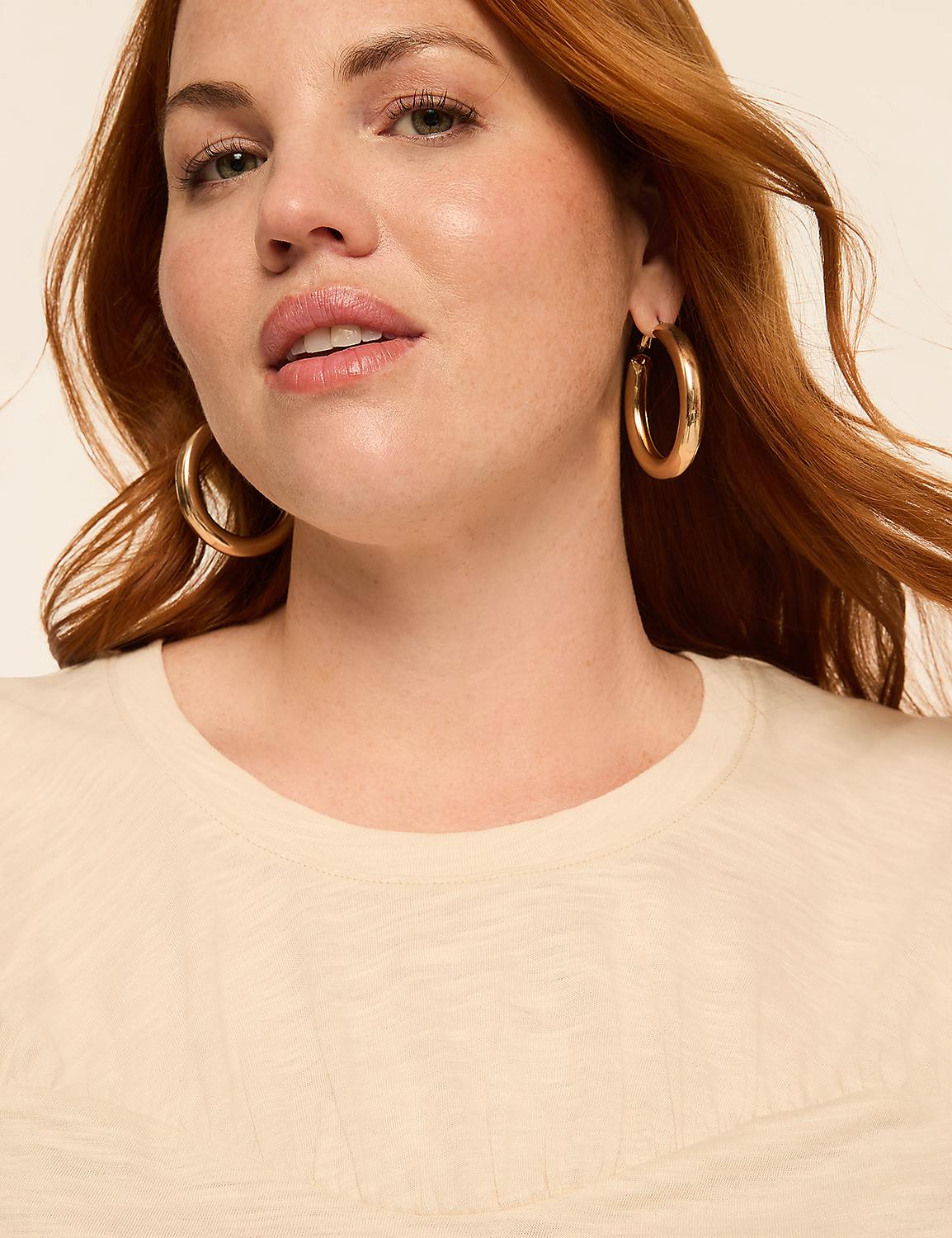 A woman with auburn hair and large hoop earrings smiles softly in the foreground, against a plain, light-colored background. Product Image 4