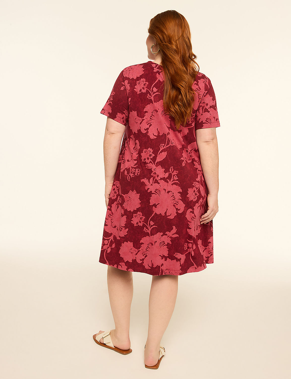 A woman with red hair wearing a floral print dress stands with her back to the camera against a plain, light-colored background. Product Image 2