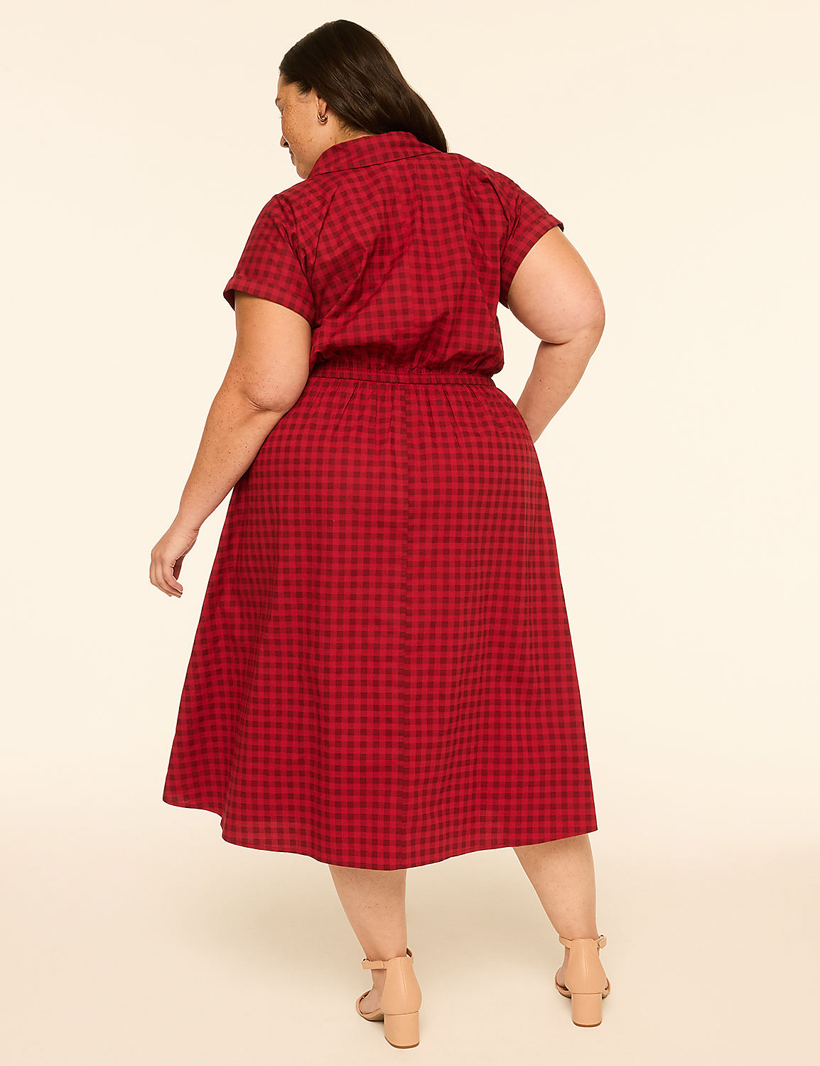 A woman in a red gingham dress stands against a plain, light-colored background. Product Image 2