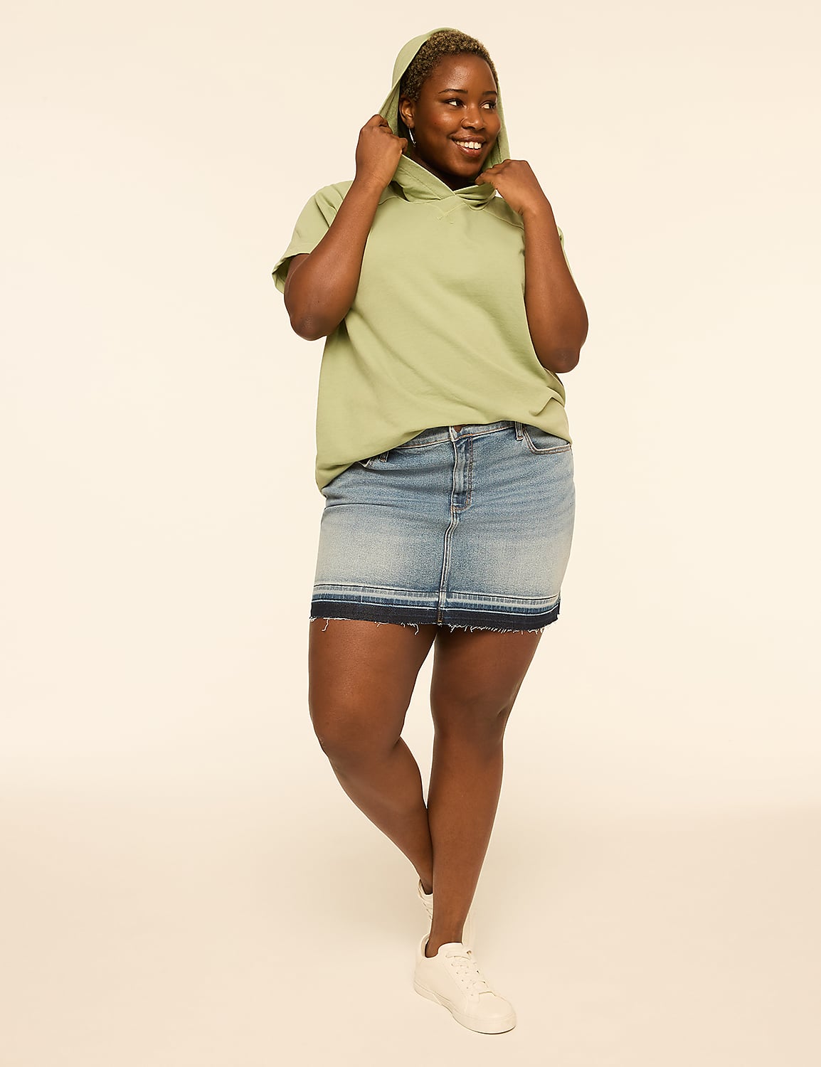 A woman in a light green hoodie and denim skirt stands against a plain, light background. Product Image 3