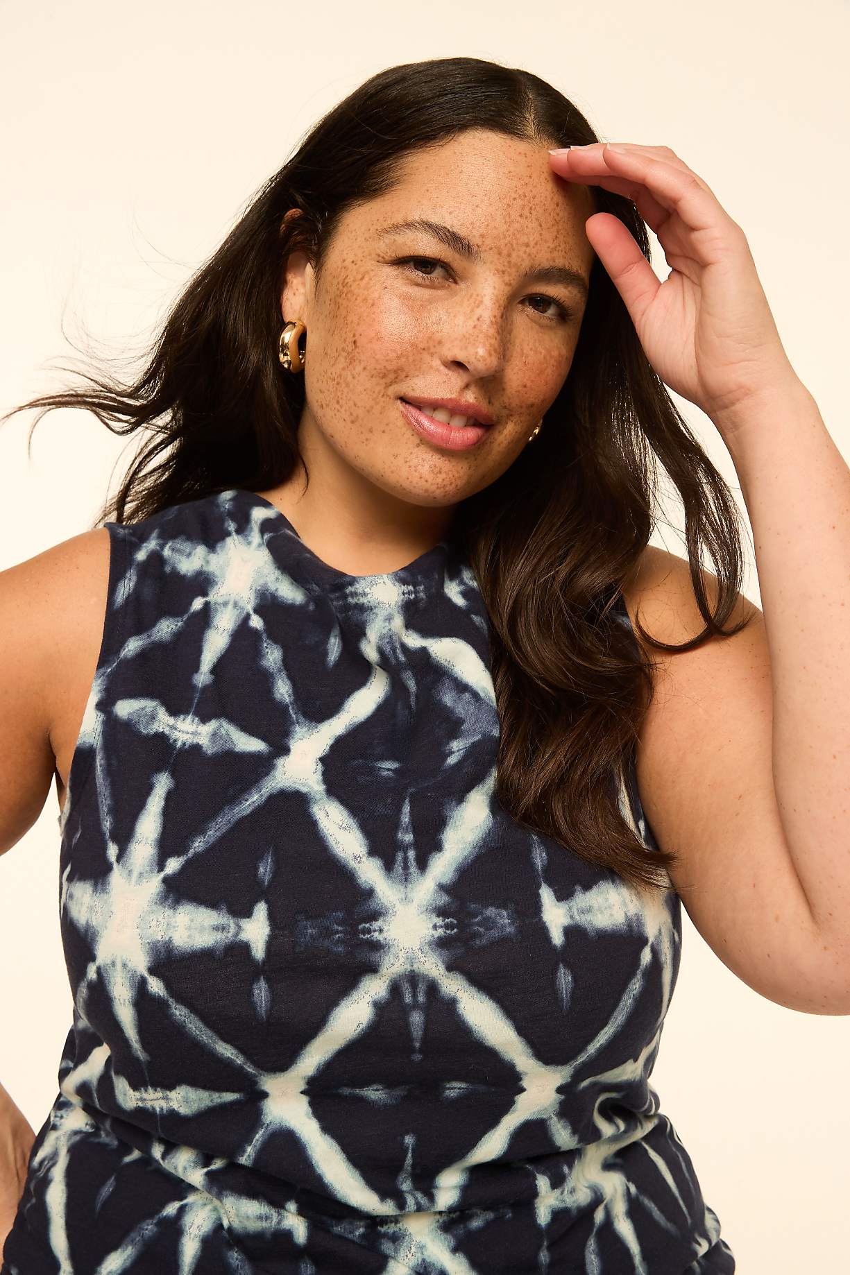 A woman with dark hair and freckles smiles at the camera, wearing a tie-dye top against a plain, light background. Product Image 9