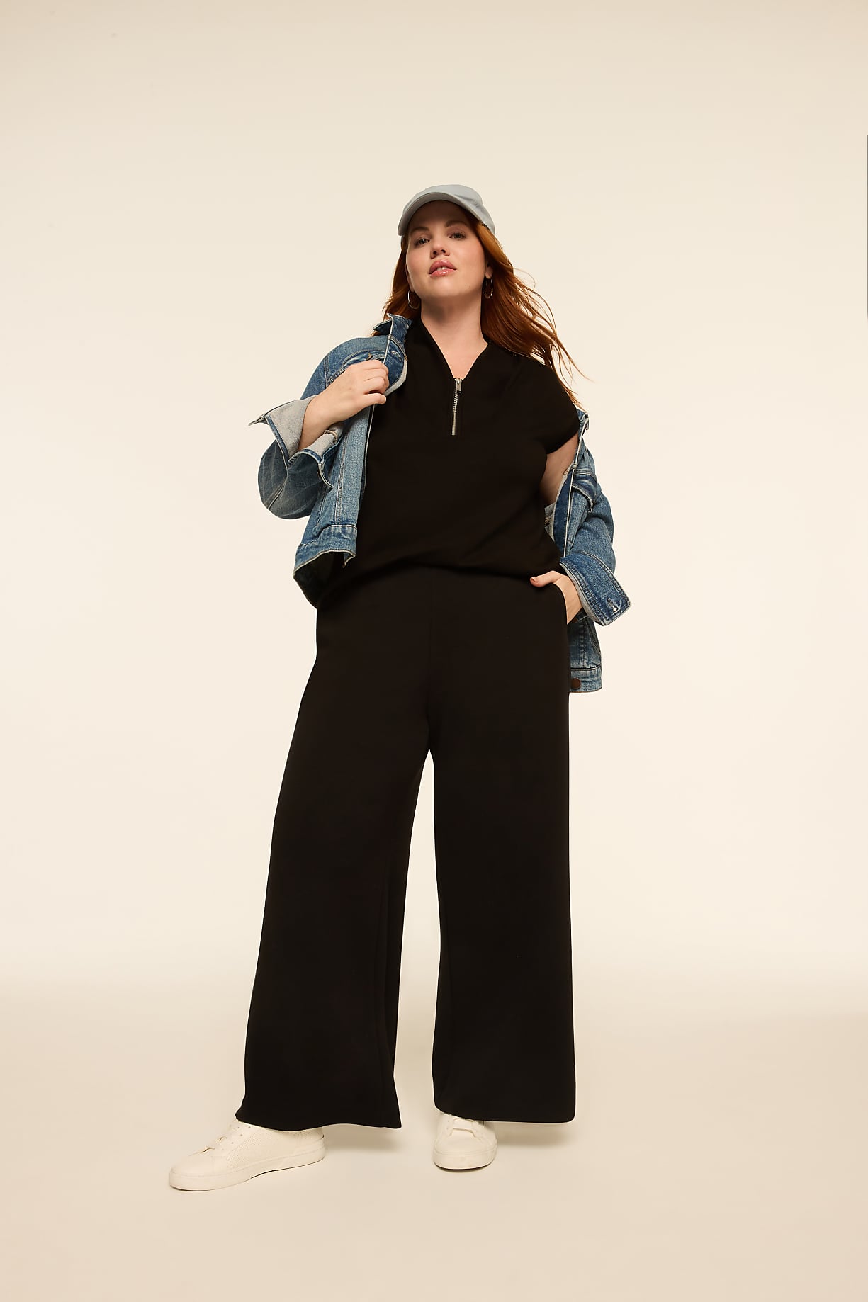 A woman in a black outfit and denim jacket stands against a plain, light background. Product Image 8