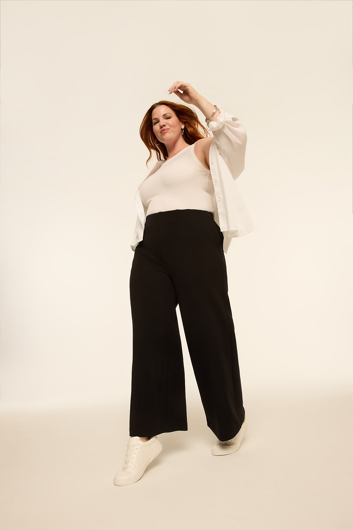 A woman in a white tank top and black wide-leg pants poses against a plain, light-colored background. Product Image 9