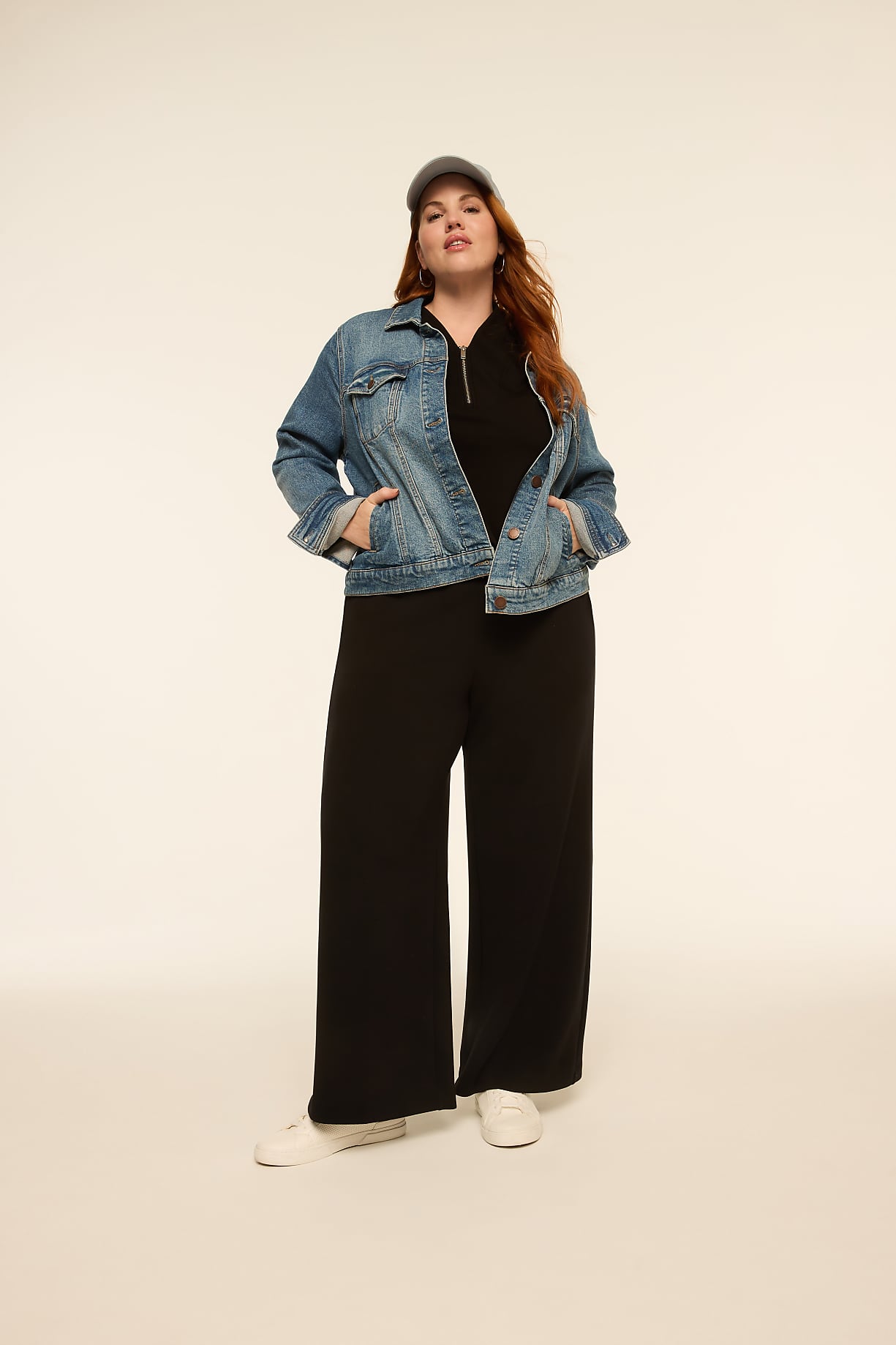 A woman in a denim jacket and black pants stands against a plain, light-colored background. Product Image 14