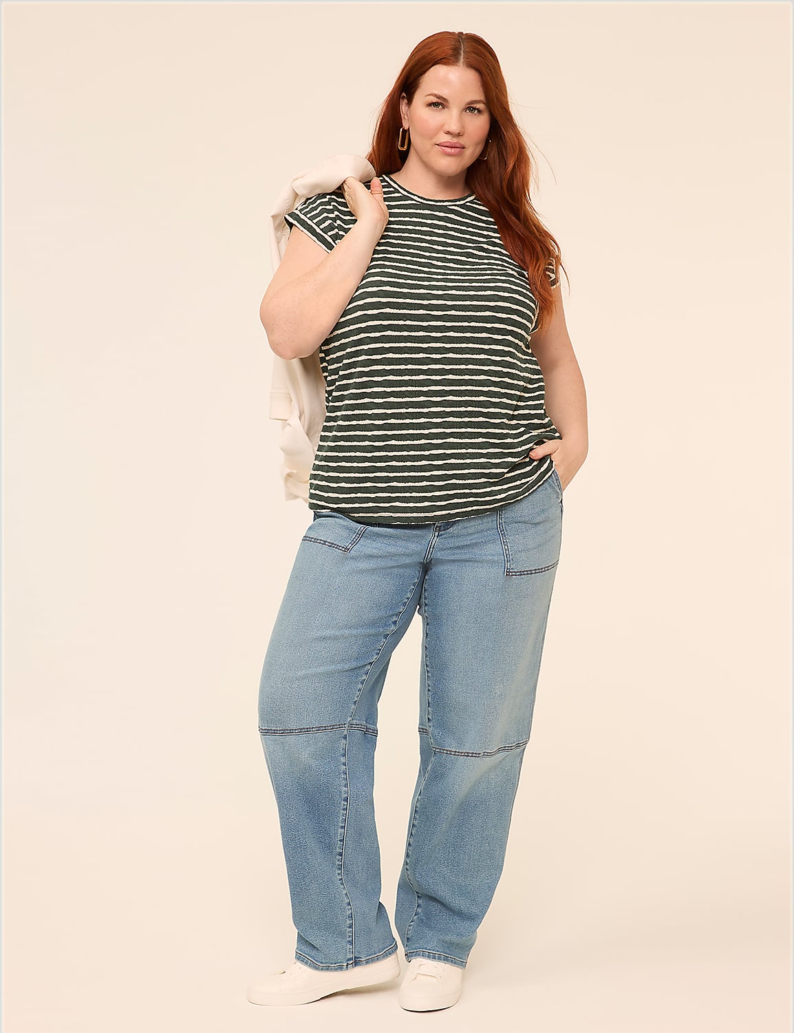 A woman with red hair stands in the foreground wearing a striped t-shirt and jeans against a plain, light-colored background. Product Image 3
