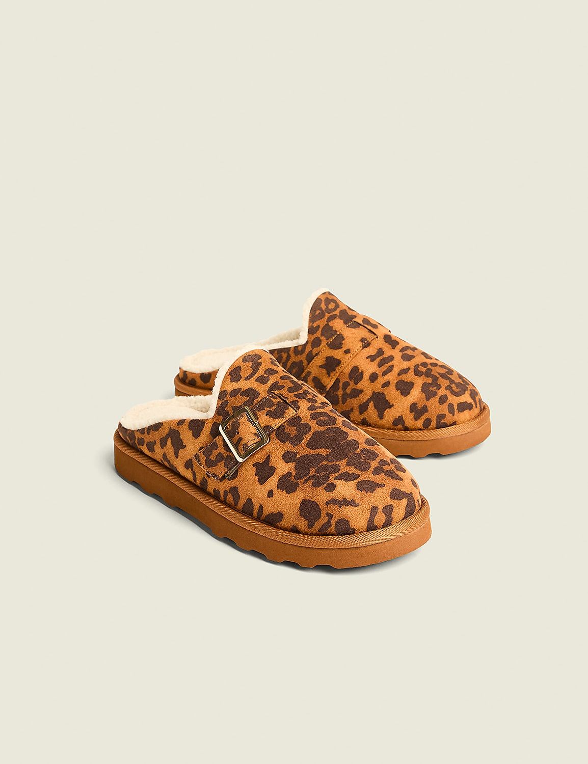 A pair of leopard-print slippers with faux fur lining rests on a plain, light-colored background. Product Image 1