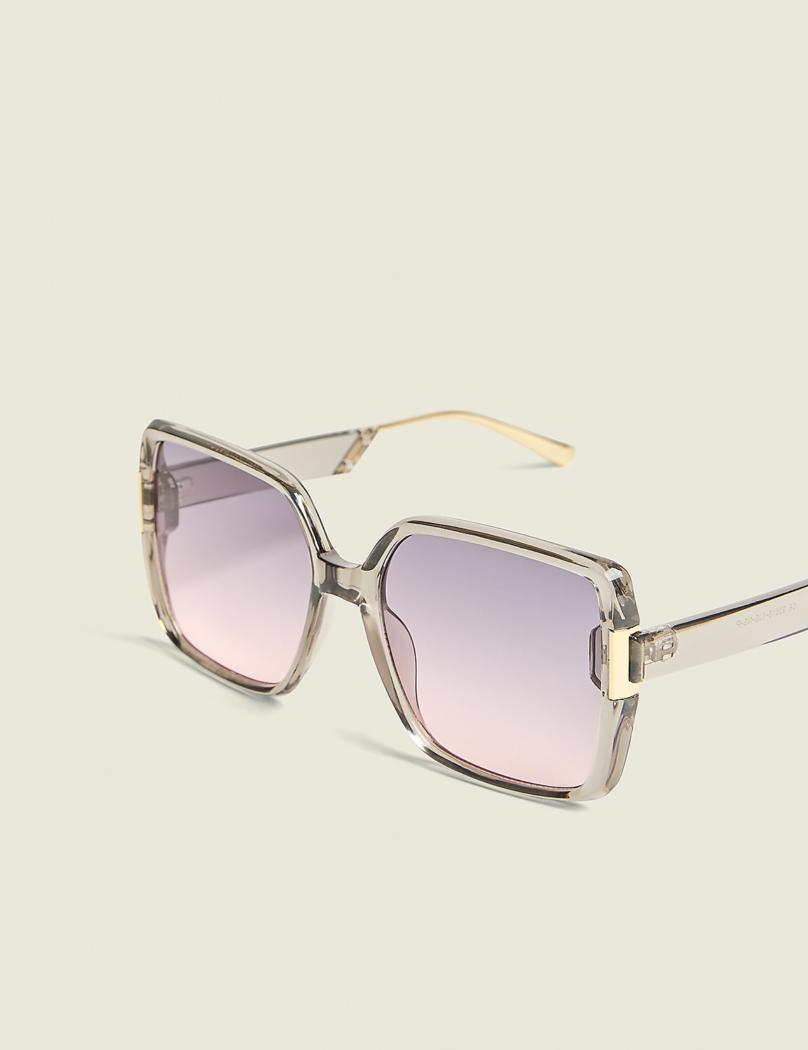 Oversized square sunglasses with a translucent grey frame and gradient pink lenses rest against a plain, light-colored background. Product Image 1