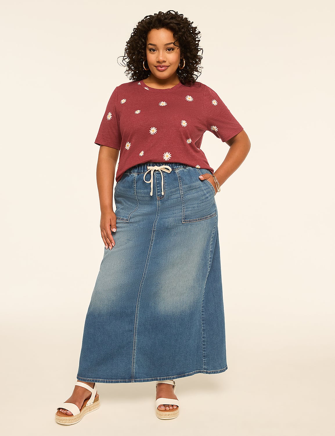 A woman in a floral t-shirt and denim maxi skirt stands against a plain, light-colored background. Product Image 3