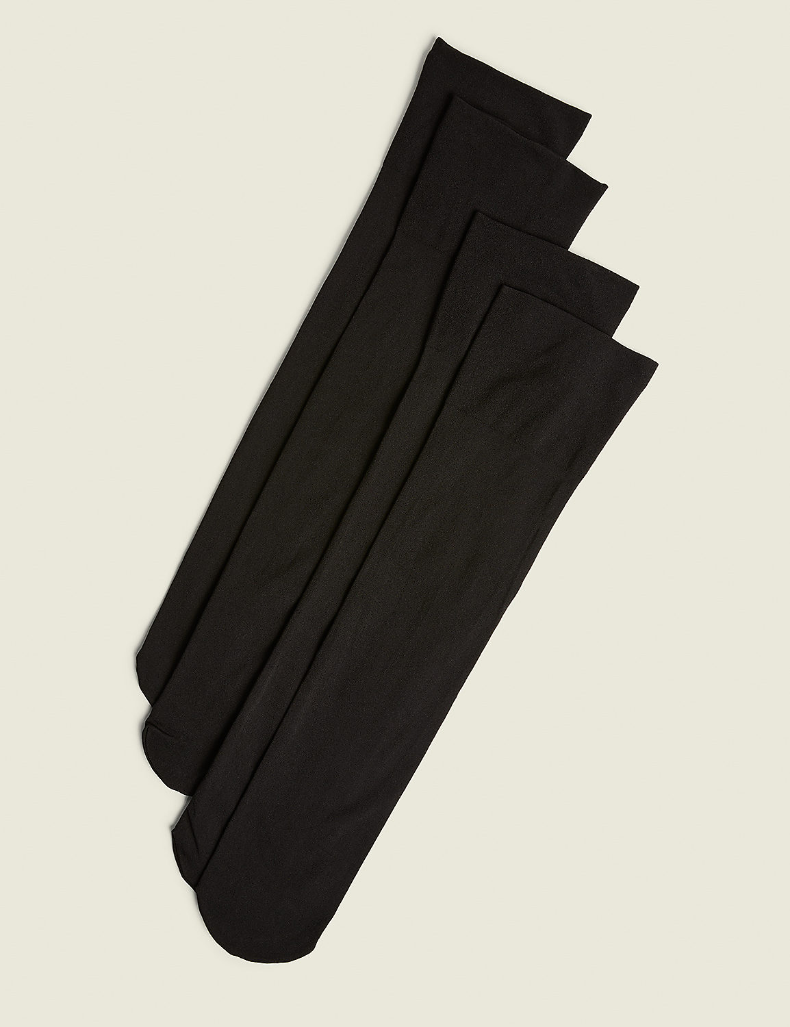 Four black knee-high socks are neatly arranged diagonally on a plain, light beige background. Product Image 1