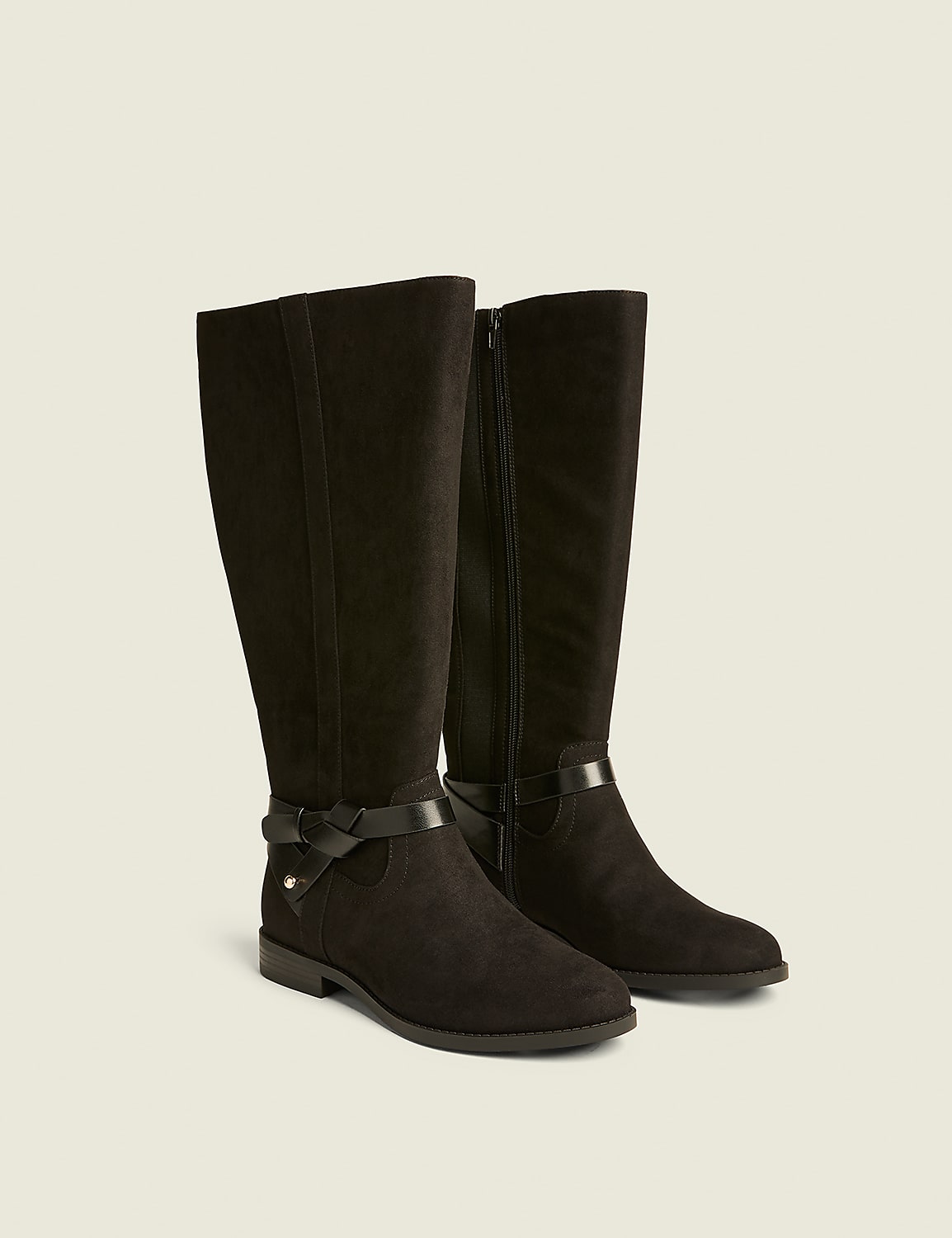A pair of black suede knee-high boots with buckle accents are displayed against a plain, light-colored background. Product Image 1