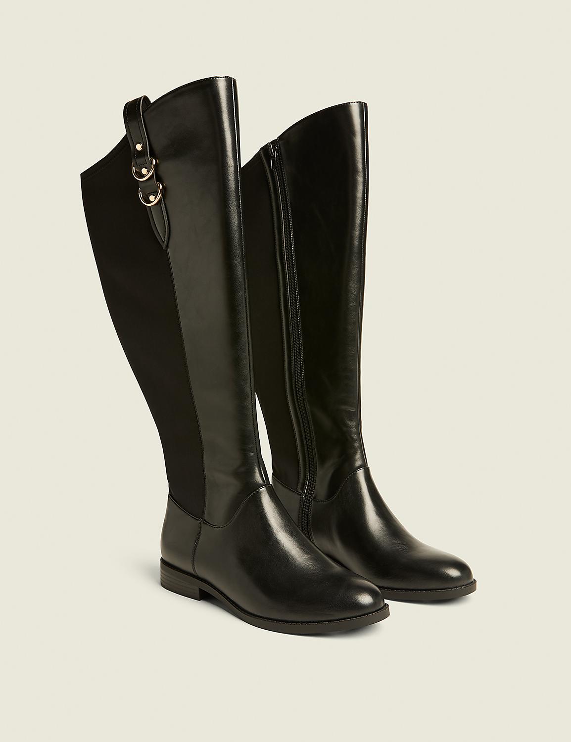 A pair of black leather knee-high boots with elastic side panels and gold buckle accents stand on a light beige background. Product Image 1