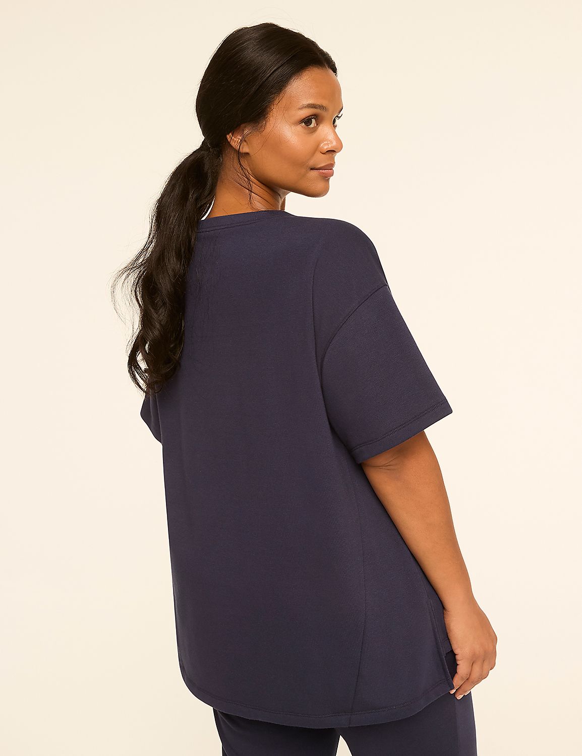 A woman in a navy blue t-shirt and pants stands against a plain, light-colored background. Product Image 2