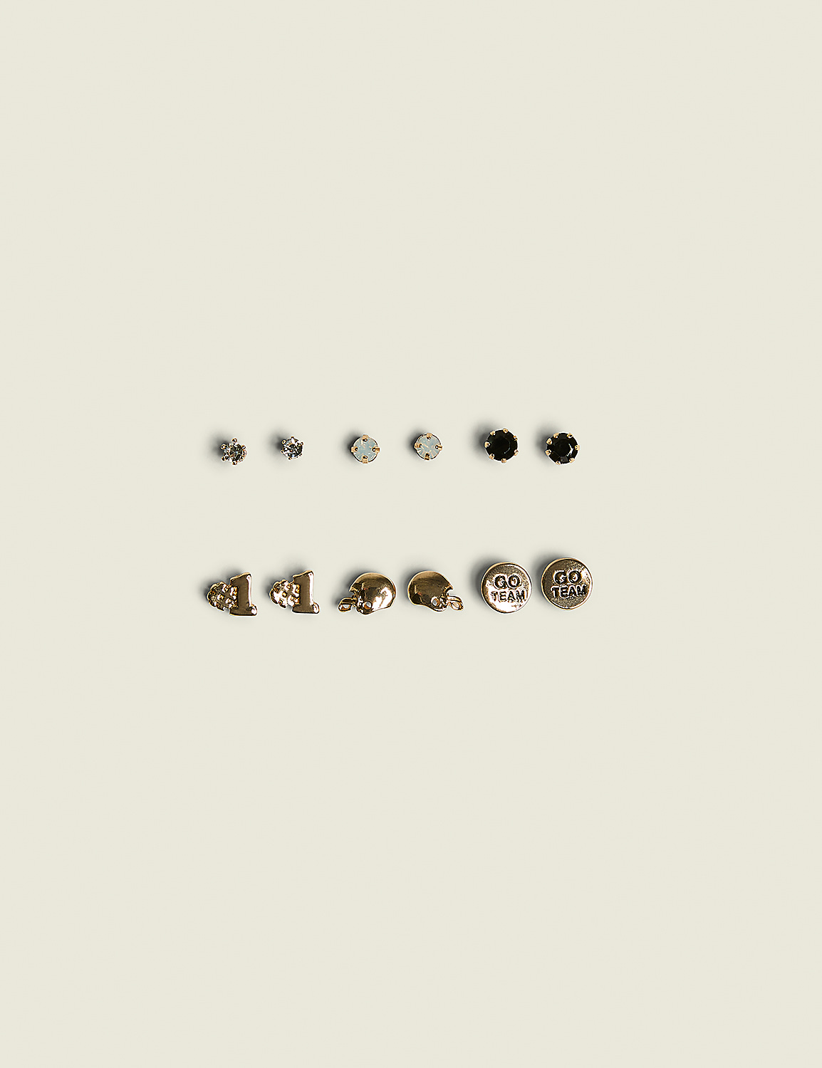 A collection of assorted earrings, including studs and charms, are arranged on a plain, light-colored background. Product Image 1