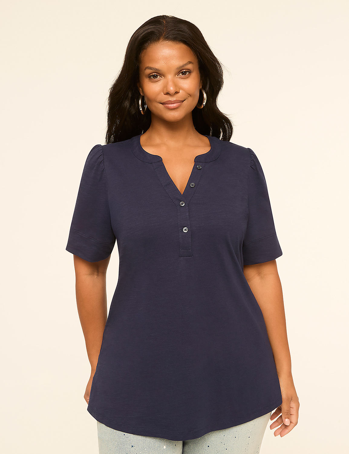 A woman in a navy blue henley shirt stands against a plain, light-colored background. Product Image 1