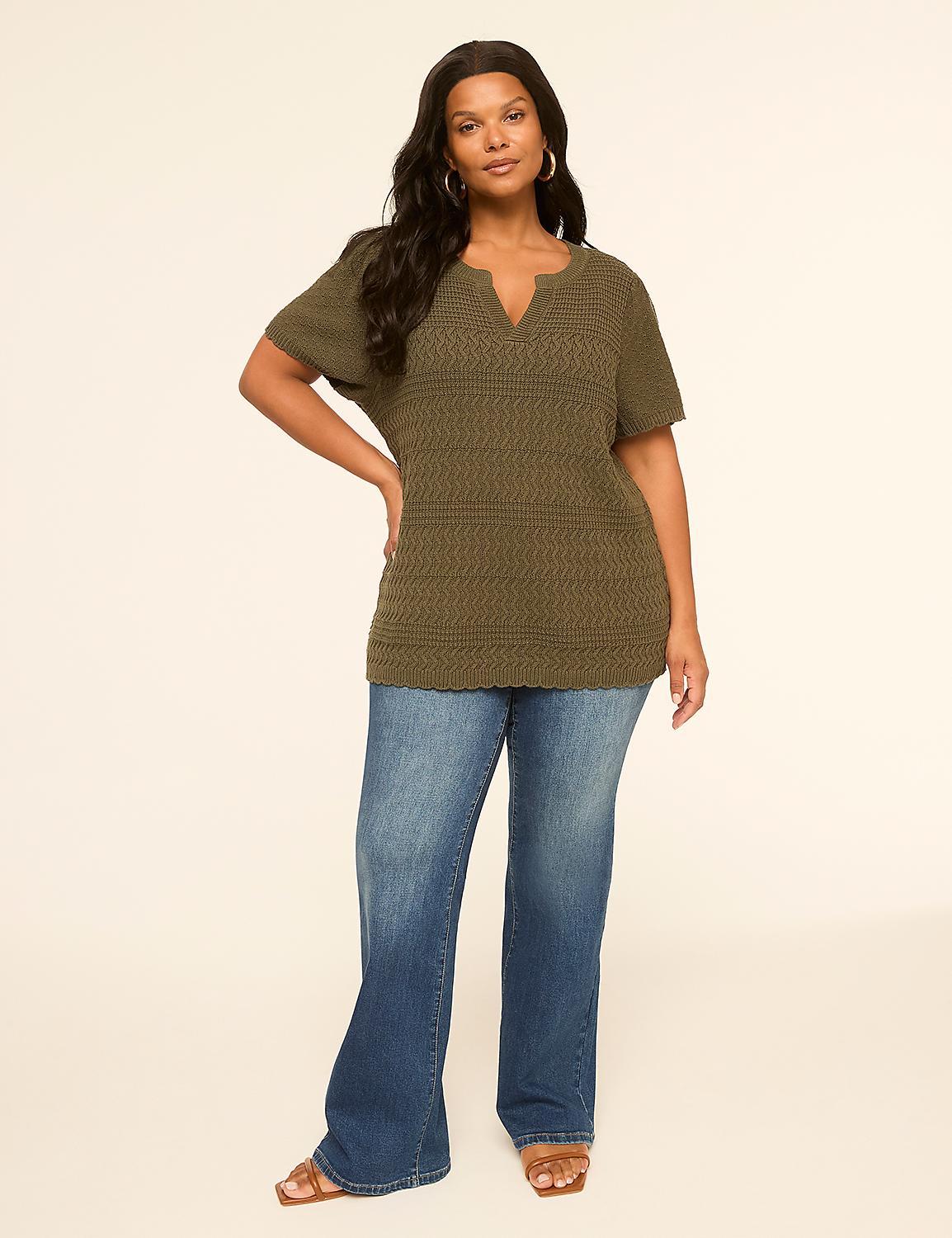 A woman in a green tunic and blue jeans stands against a plain, light-colored background. Product Image 3