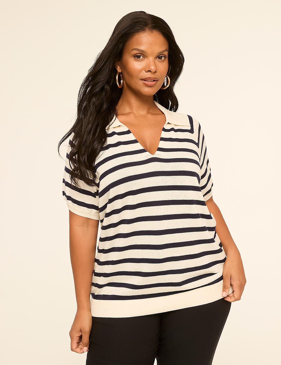 A woman with dark hair and hoop earrings poses in a cream and navy striped collared shirt against a plain, light background. Product Image 1