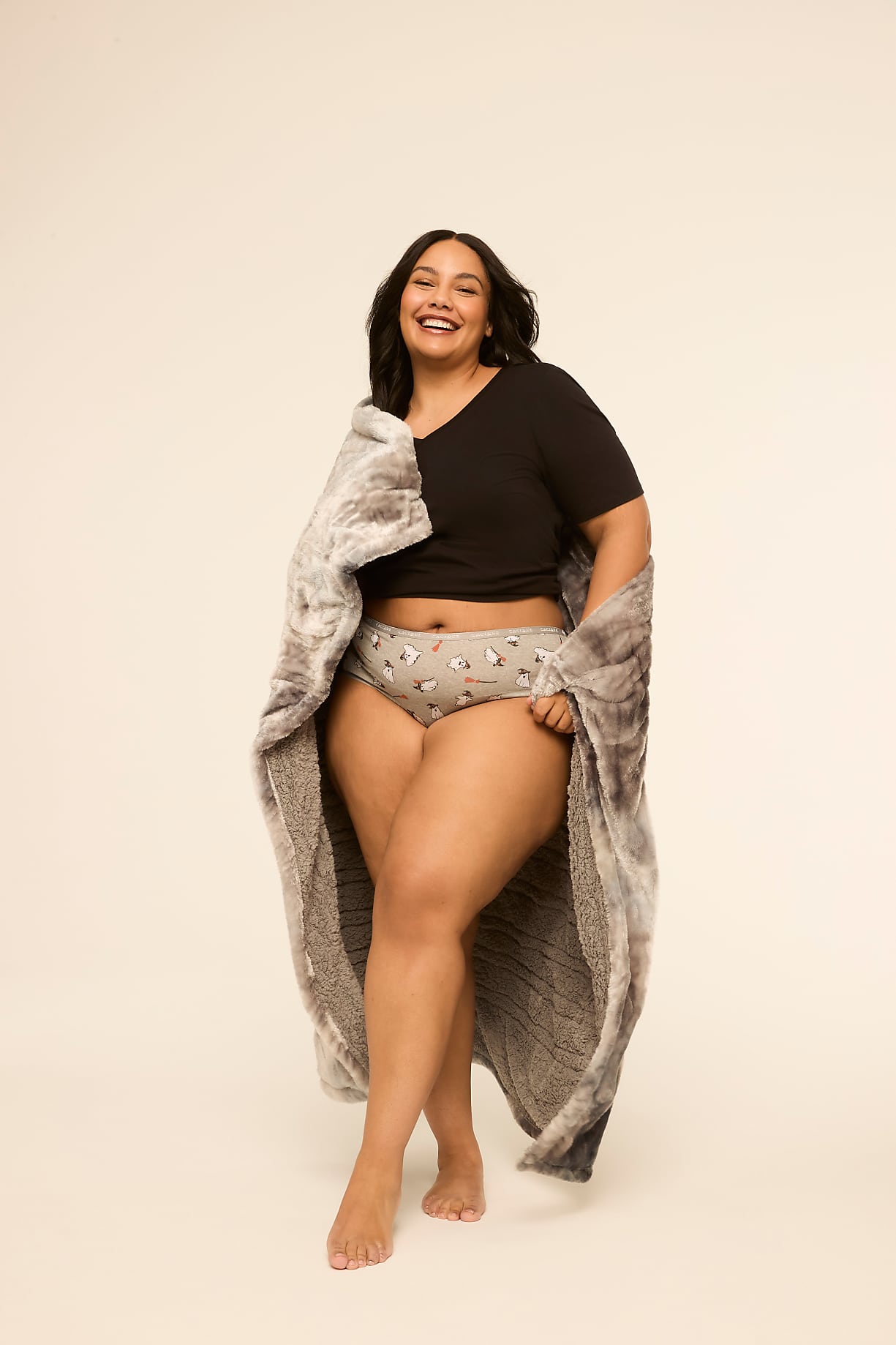 A smiling woman in a black top and patterned underwear is wrapped in a fluffy gray blanket against a plain, light background. Product Image 4