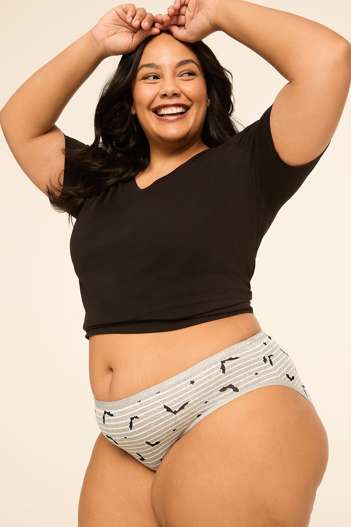 A smiling woman in a black crop top and striped underwear poses against a plain, light-colored background. Product Image 6