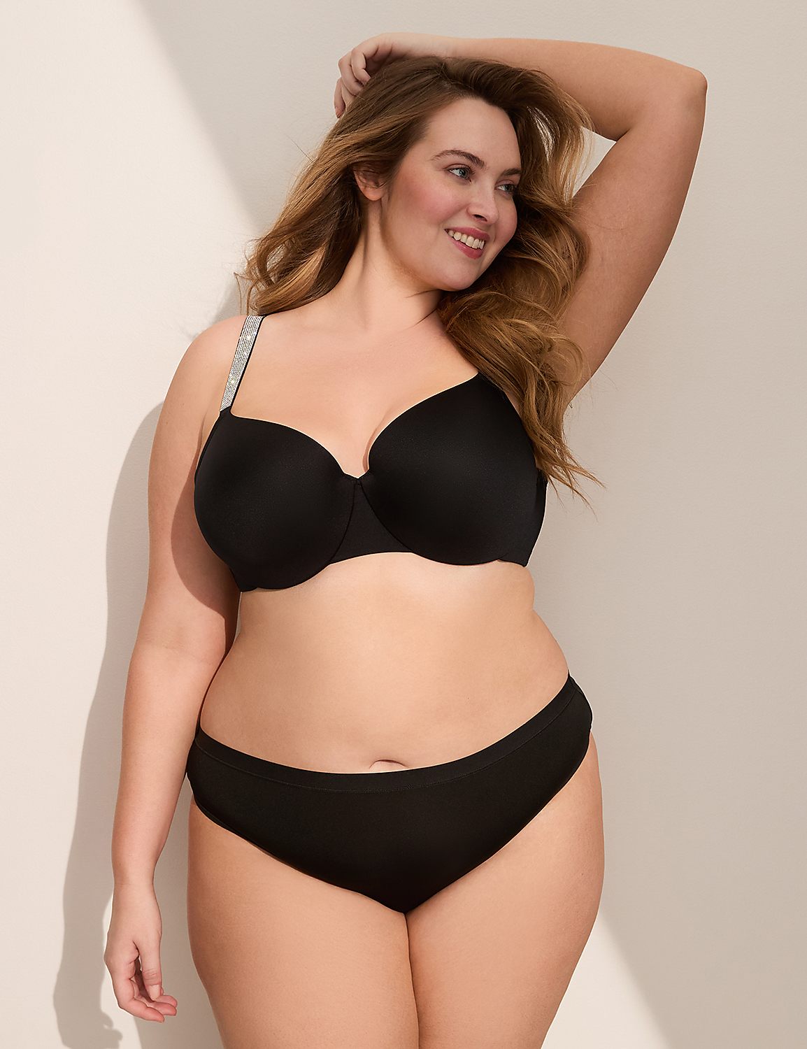 A woman in a black bra and underwear poses against a white wall with soft lighting. Product Image 4