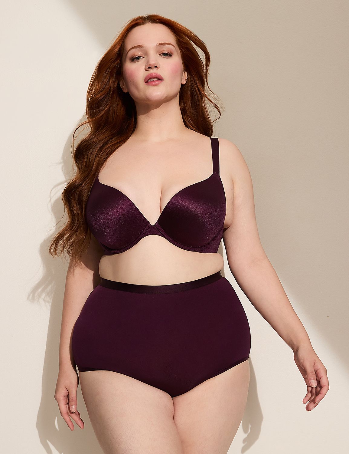 A woman with long red hair poses in a plum-colored bra and high-waisted underwear against a plain, softly lit background. Product Image 3