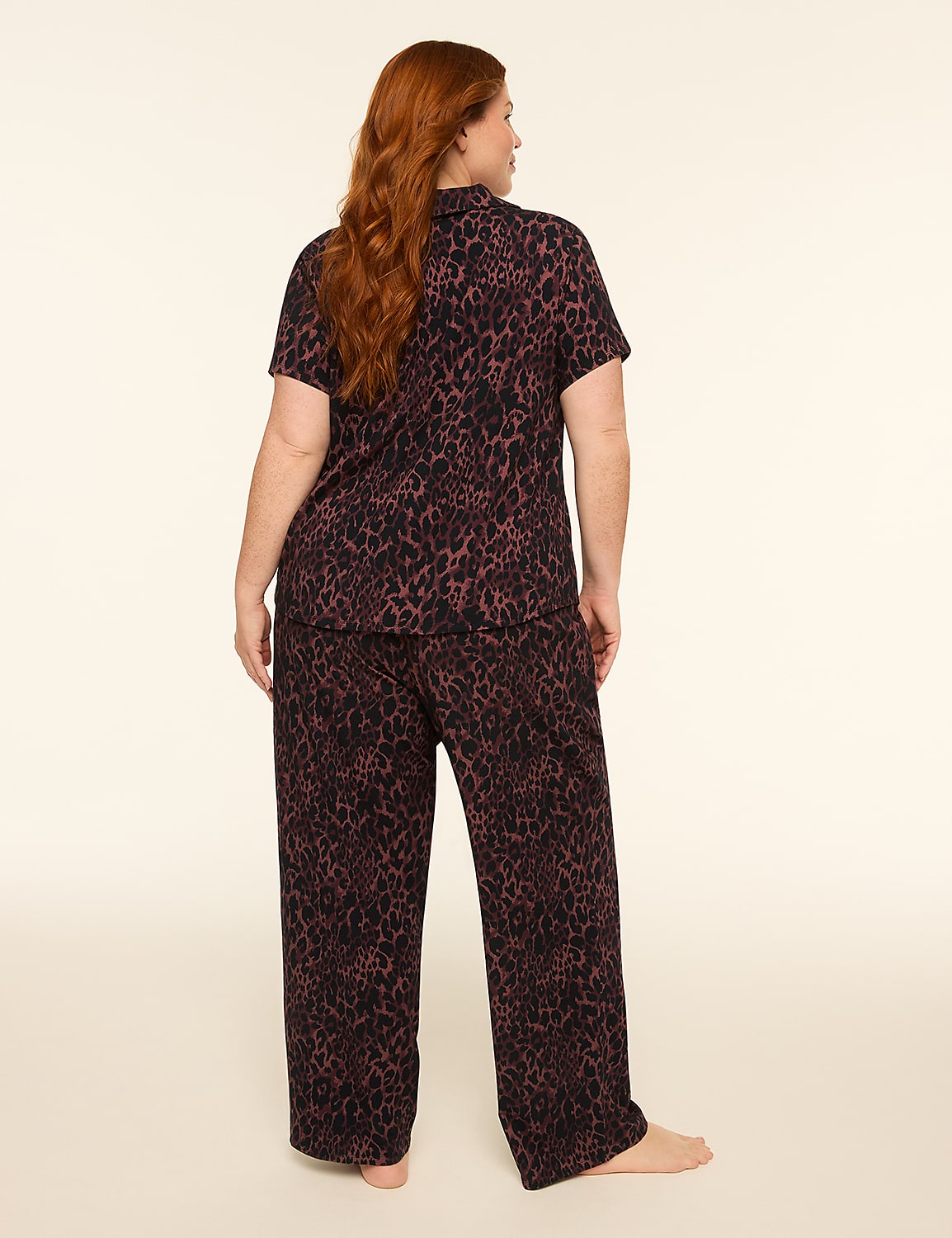 A woman with red hair stands facing away from the camera in leopard-print pajamas against a plain, light-colored background. Product Image 2