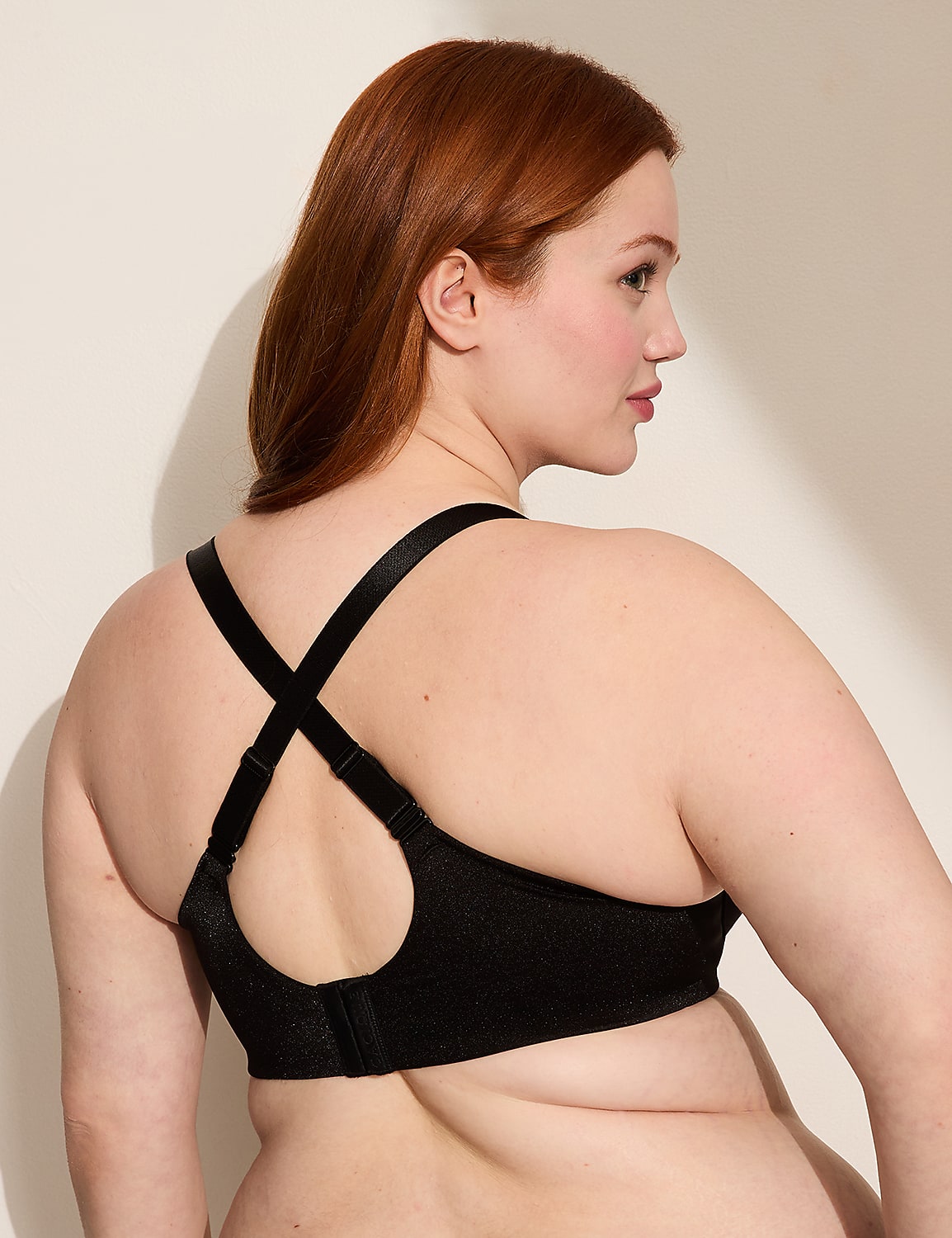 A woman with red hair is shown from the back wearing a black bra with criss-cross straps against a plain, light-colored background. Product Image 4