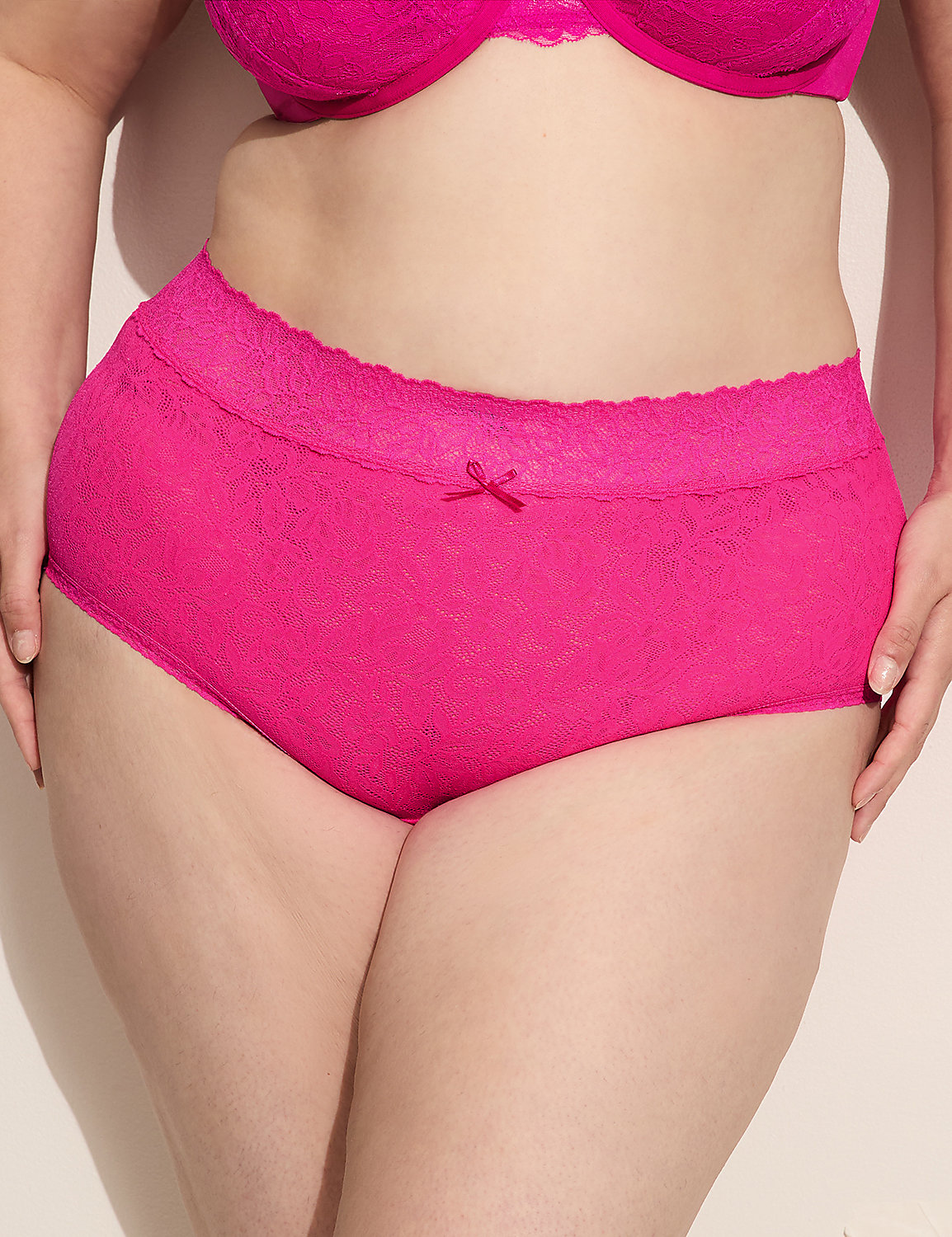 A person's torso is shown from the waist down, wearing bright pink lace-trimmed underwear and a matching bra, against a plain, light-colored background. Product Image 1