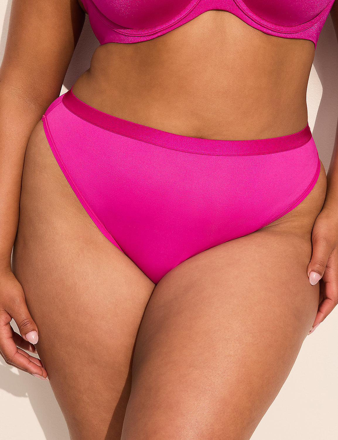 A close-up of a person's torso wearing bright pink underwear and a matching bra is set against a plain, light-colored background. Product Image 1