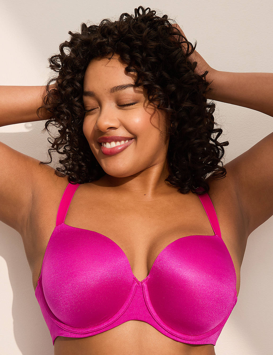 A smiling woman with curly hair poses in a bright pink bra against a plain white background. Product Image 1