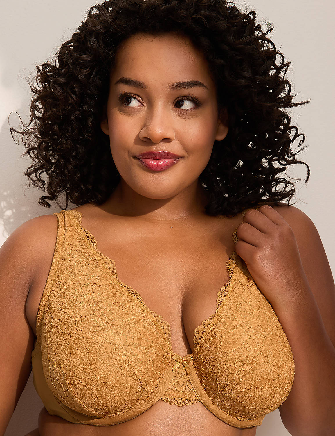 A woman with curly dark hair and a mustard-colored lace bra is posed against a plain, light-colored background. Product Image 1