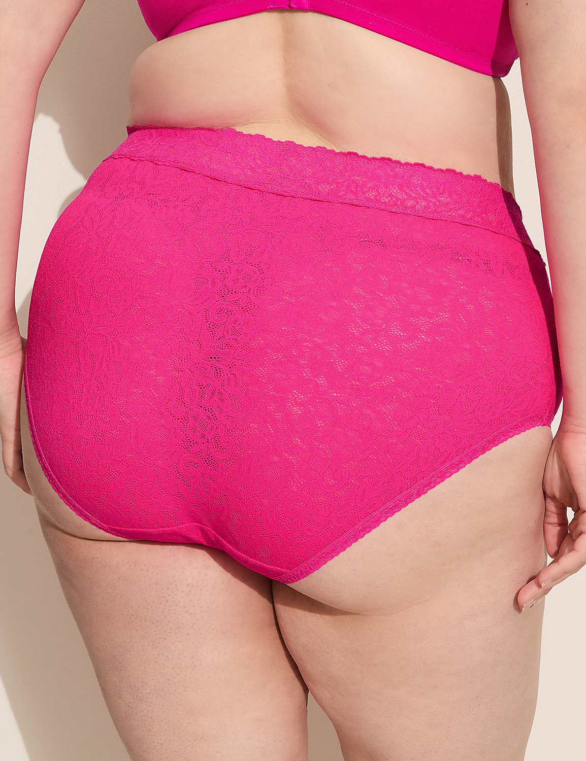 A person's lower back and buttocks are covered in bright pink lace underwear, with a plain wall in the background. Product Image 2
