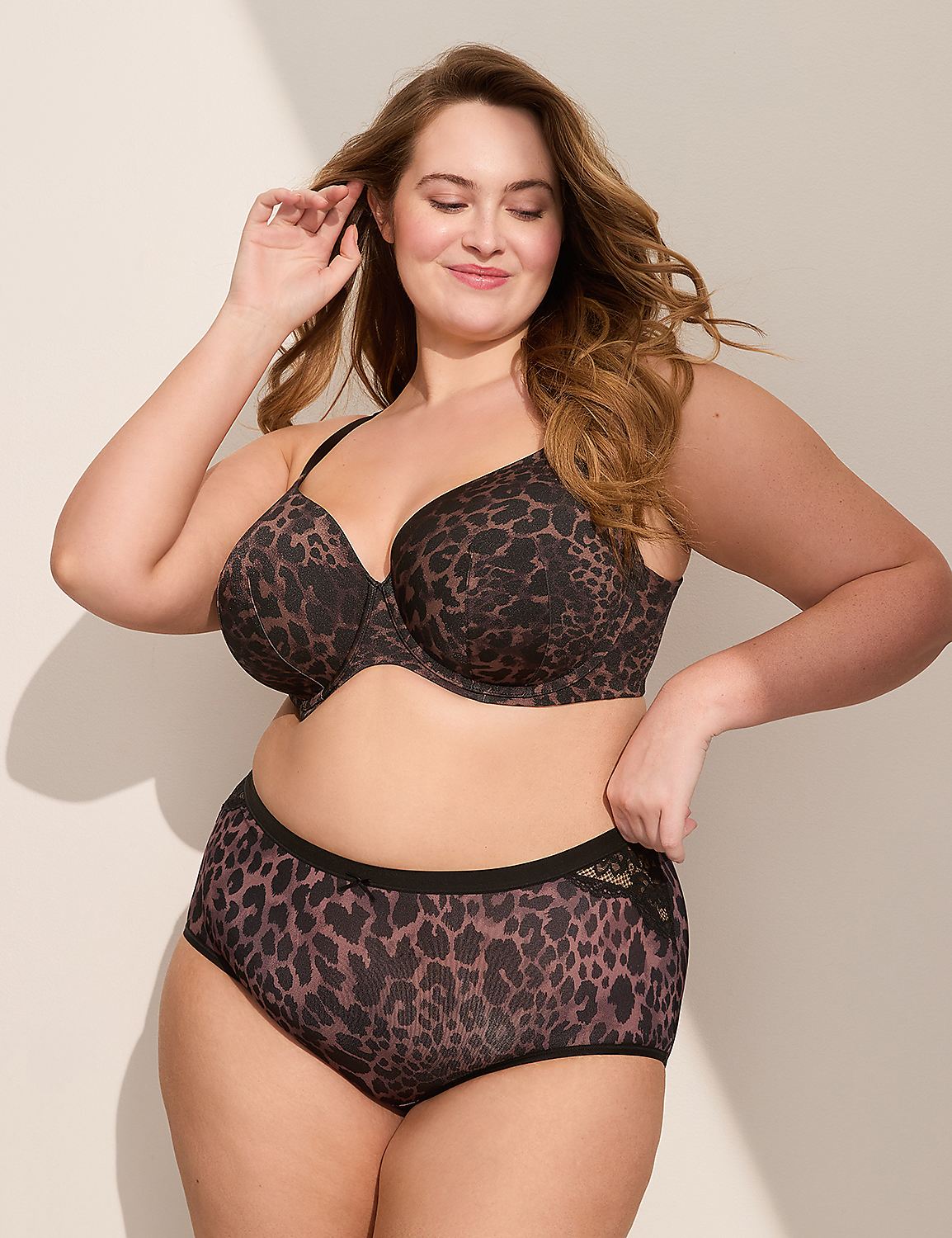 A plus-size woman in a leopard print bra and matching high-waisted briefs poses against a plain, softly lit background. Product Image 3