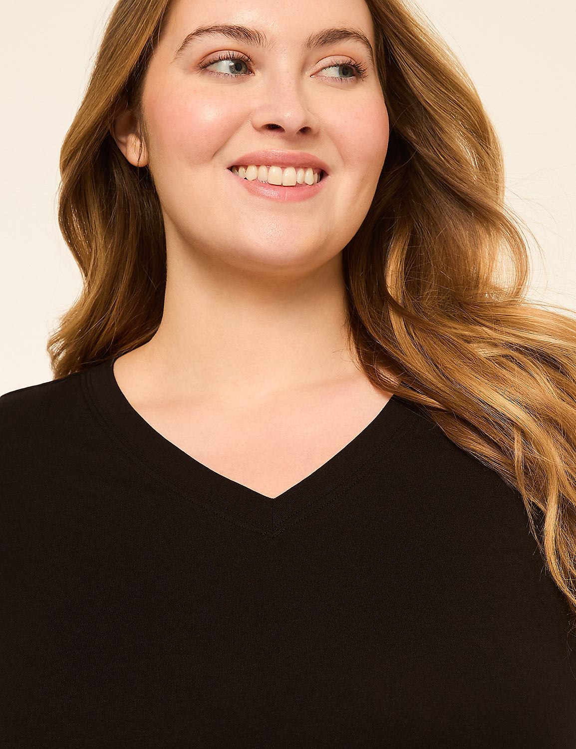 A smiling woman with blonde hair wears a black v-neck shirt against a plain, light-colored background. Product Image 4