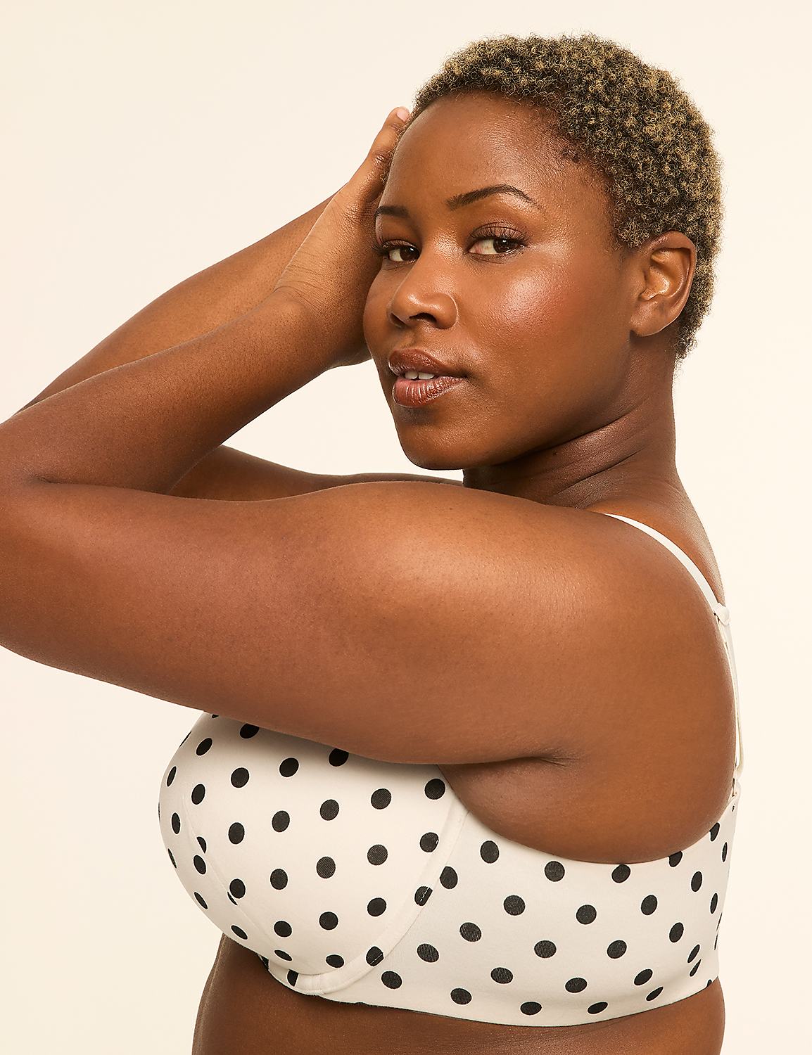 A woman with short, curly hair and a polka-dot bra poses with her arms behind her head against a plain, light background. Product Image 3