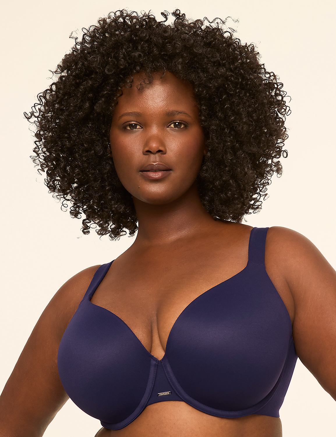 A woman with dark, curly hair and a navy blue bra is centered against a plain, light-colored background. Product Image 1