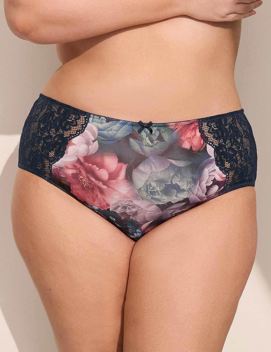 A woman's lower torso is adorned with floral-patterned underwear featuring lace trim, set against a plain, light-colored background. Product Image 1