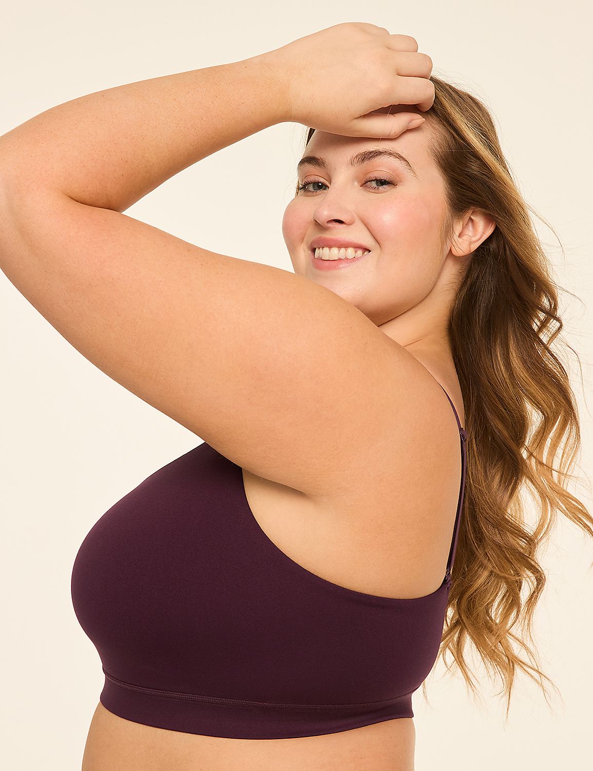 A smiling woman with long, wavy blonde hair poses with her arm raised against a plain, light-colored background. Product Image 3
