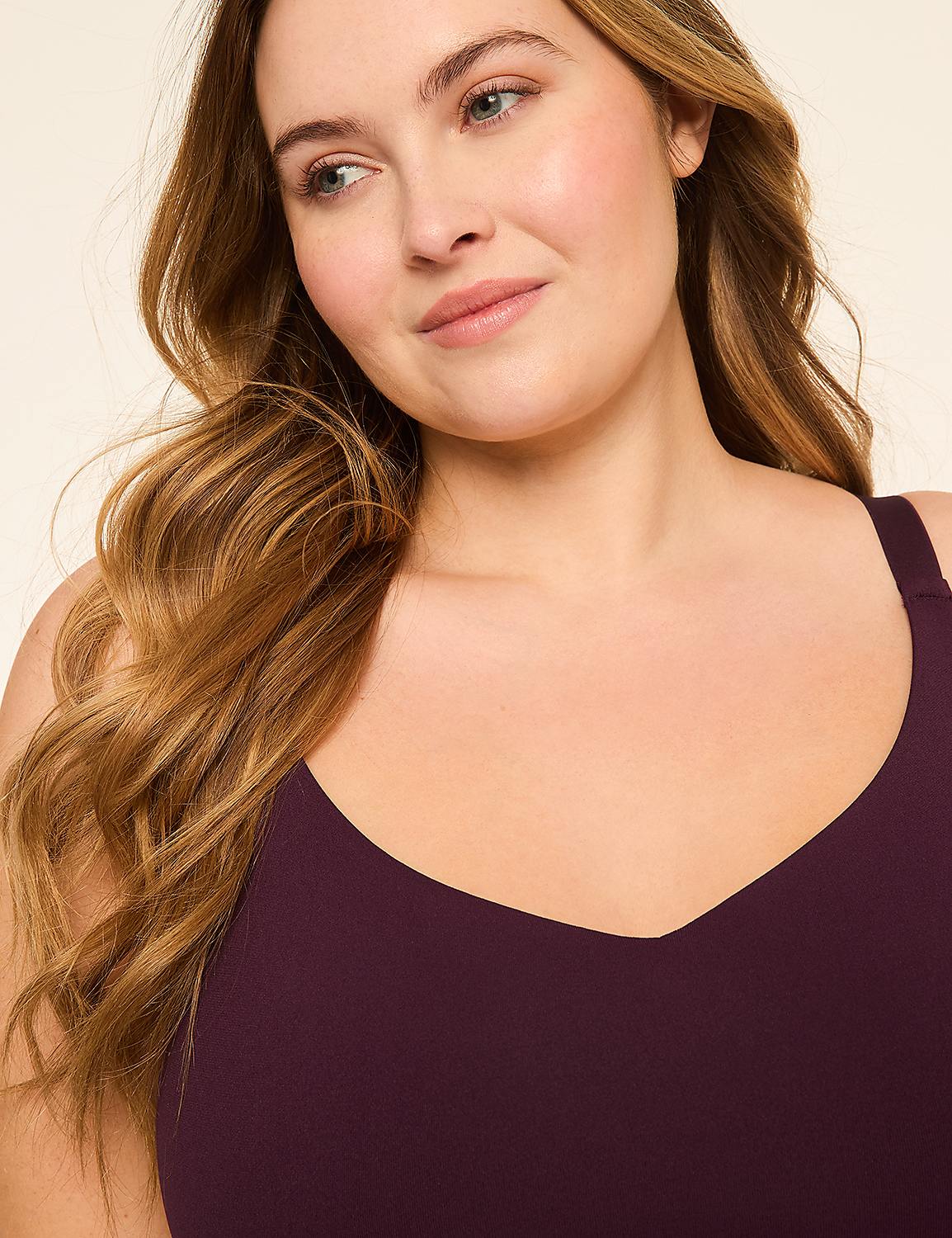 A woman with long, wavy blonde hair and a plum-colored top is shown against a plain, light-colored background. Product Image 4