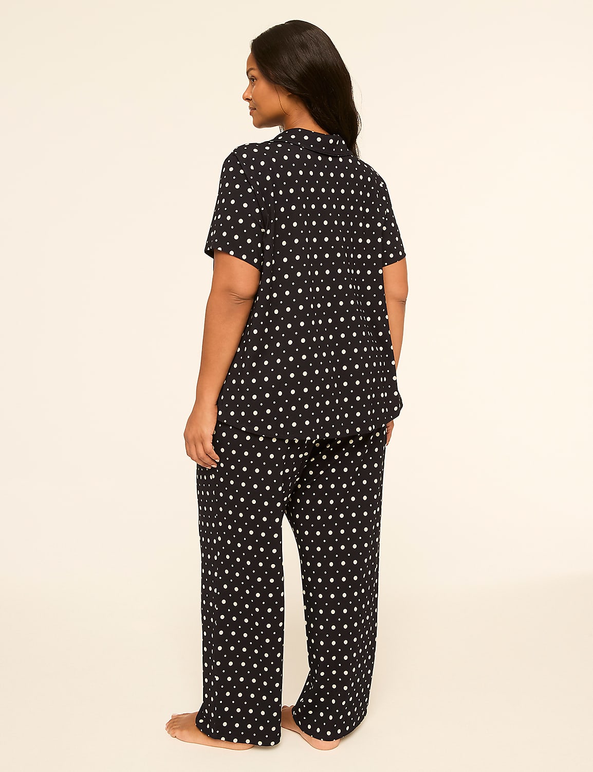 A woman in black pajamas with a white star pattern stands against a plain, light-colored background. Product Image 2