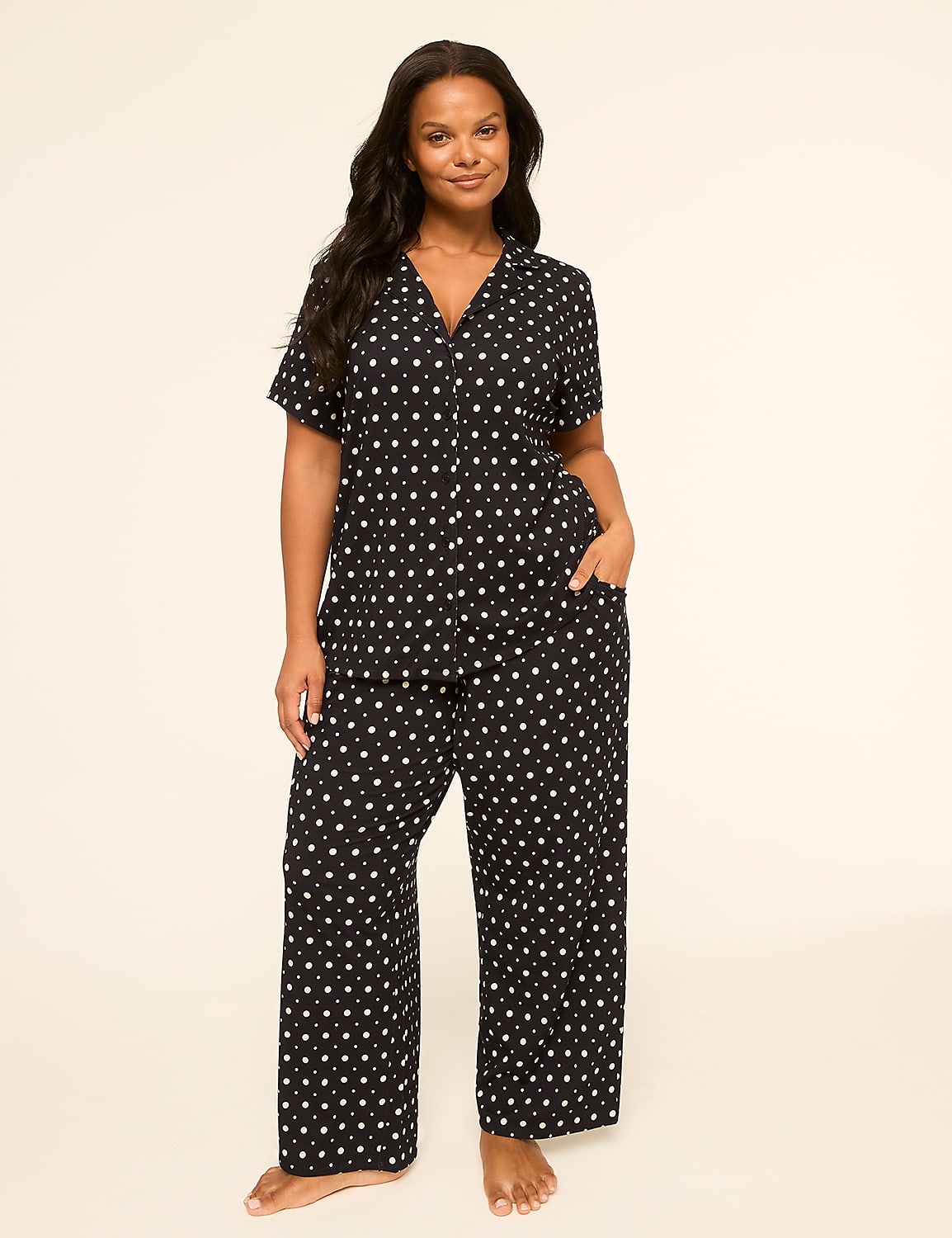 A woman in a polka dot pajama set stands against a plain, light-colored background. Product Image 5