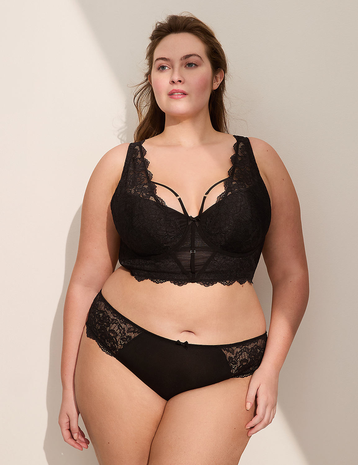 A woman in black lace lingerie stands against a plain, light-colored background. Product Image 4