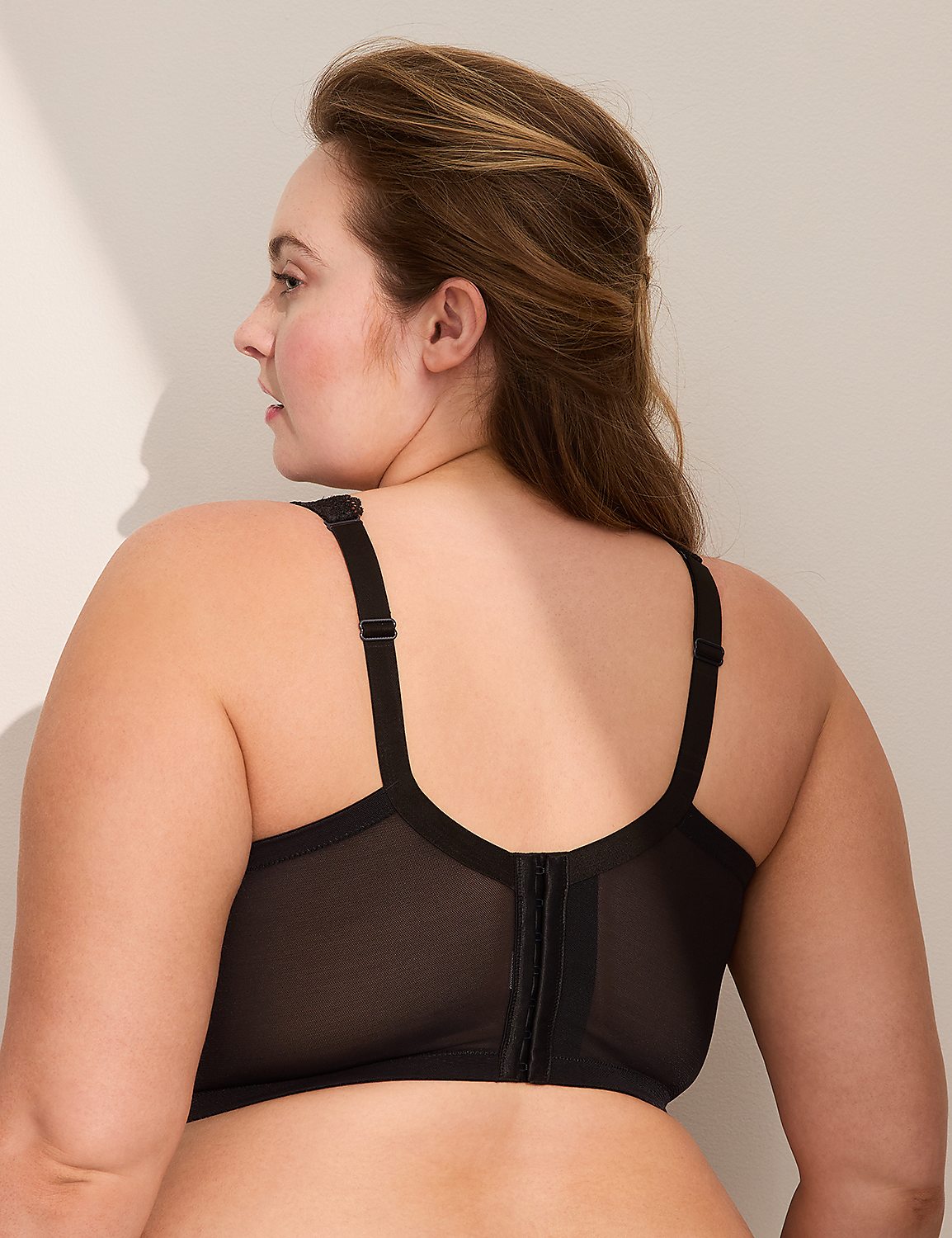 A woman in a black bra is shown from the back, with a plain, light-colored wall in the background. Product Image 3