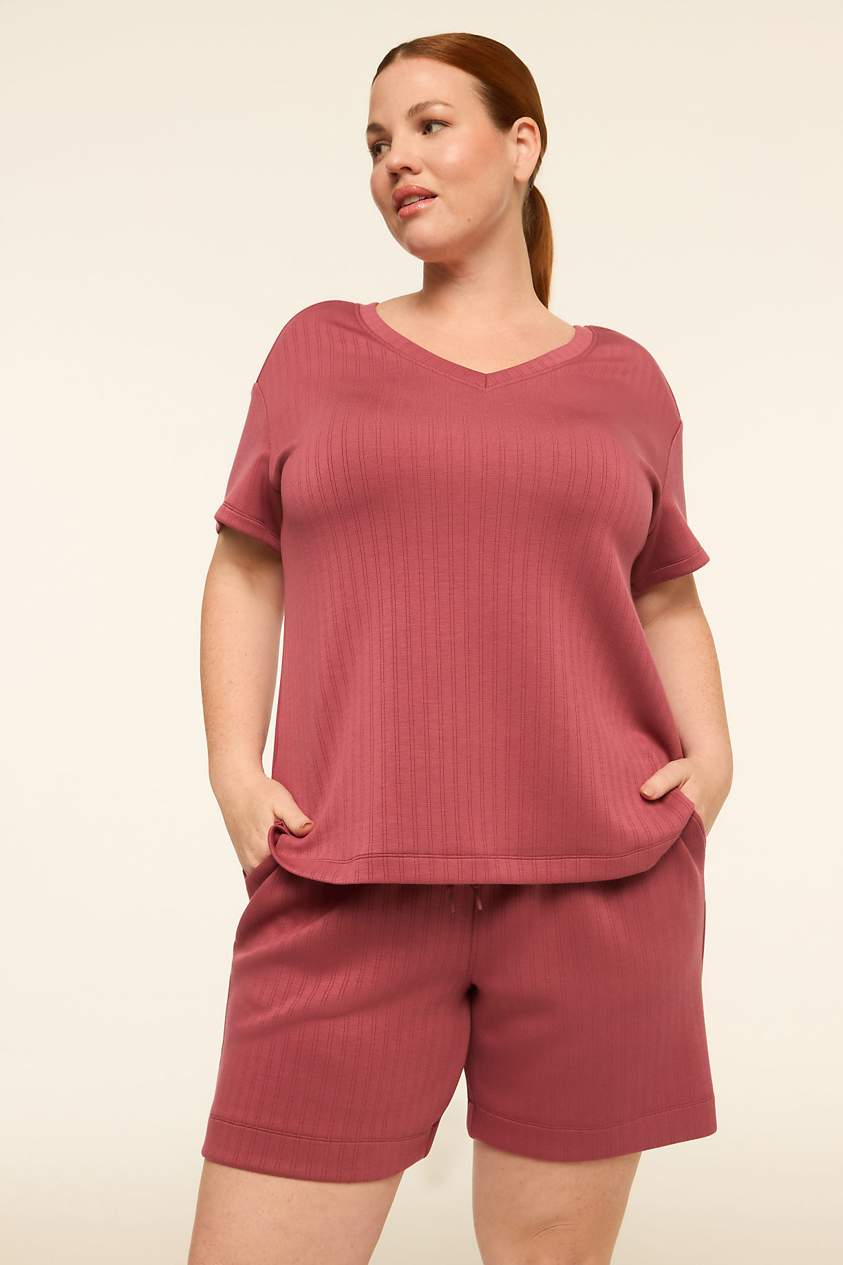 A woman in a mauve v-neck t-shirt and matching shorts stands against a plain, light-colored background. Product Image 6