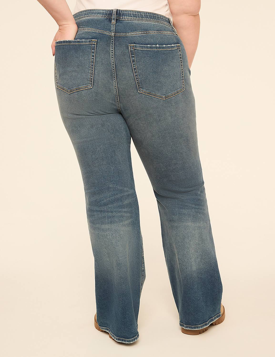 A person wearing flared denim jeans stands against a plain, light-colored background. Product Image 2