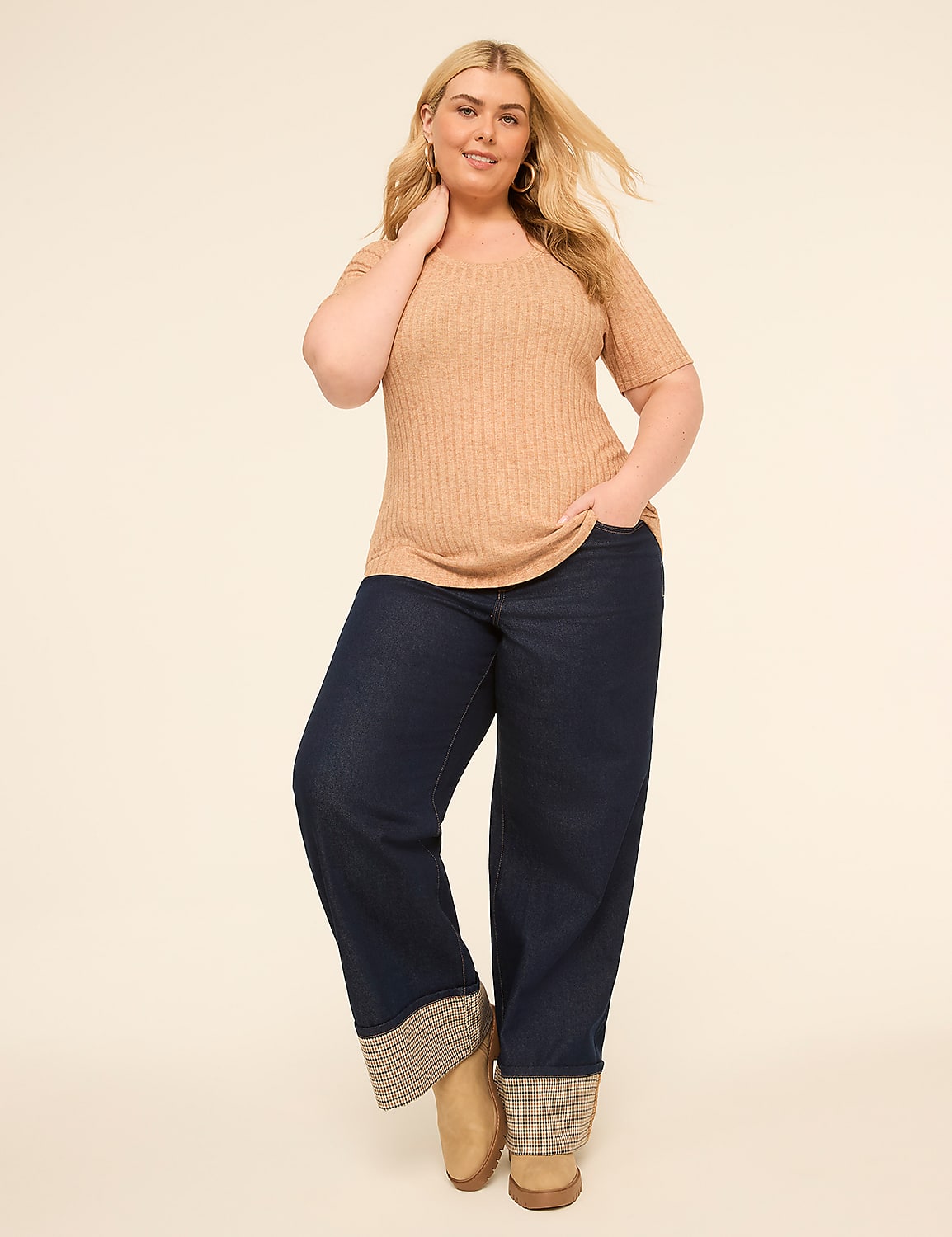 A woman in a tan ribbed shirt and dark wide-leg jeans stands against a plain beige background. Product Image 3