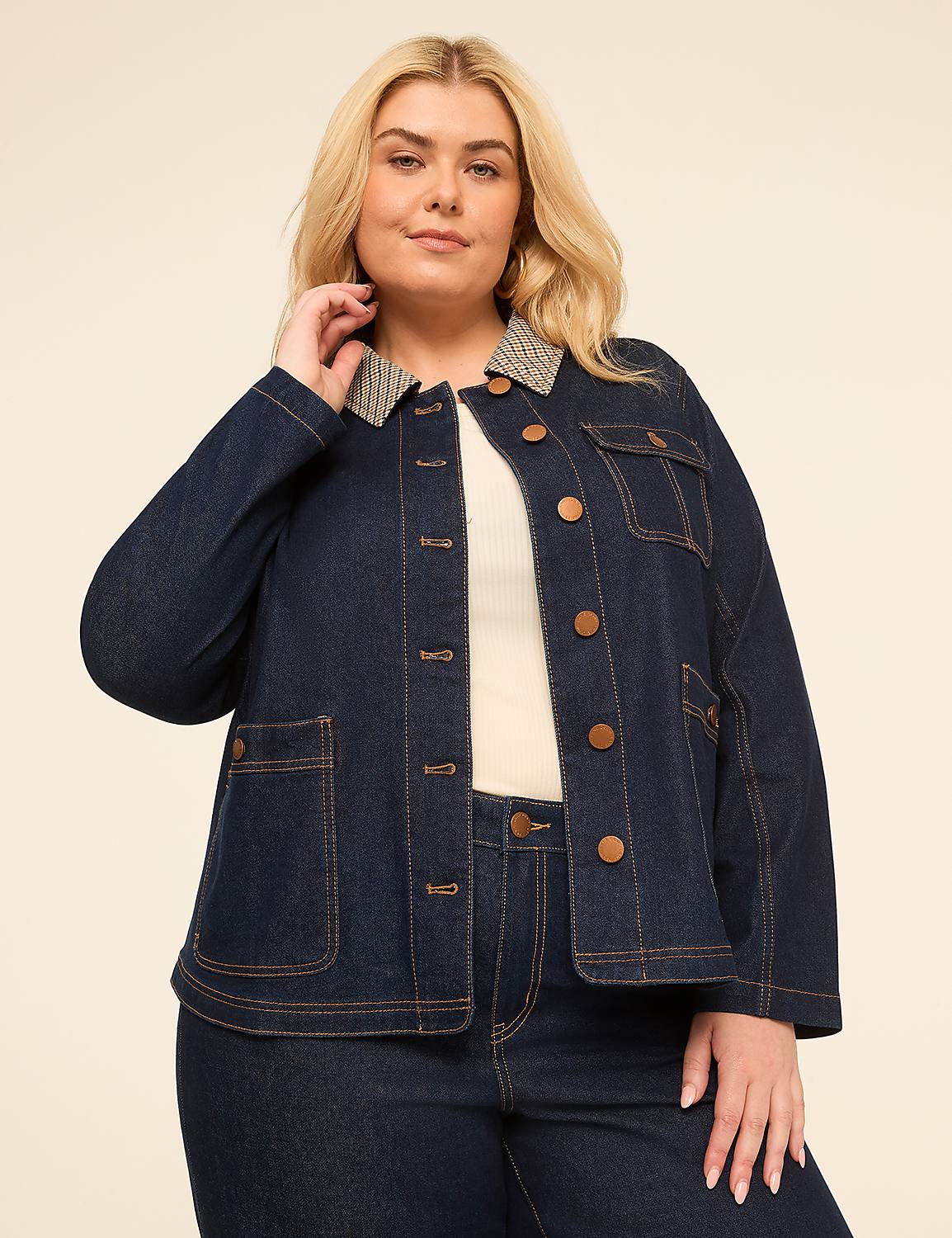 A plus-size woman in a denim jacket stands against a plain, light-colored background. Product Image 1