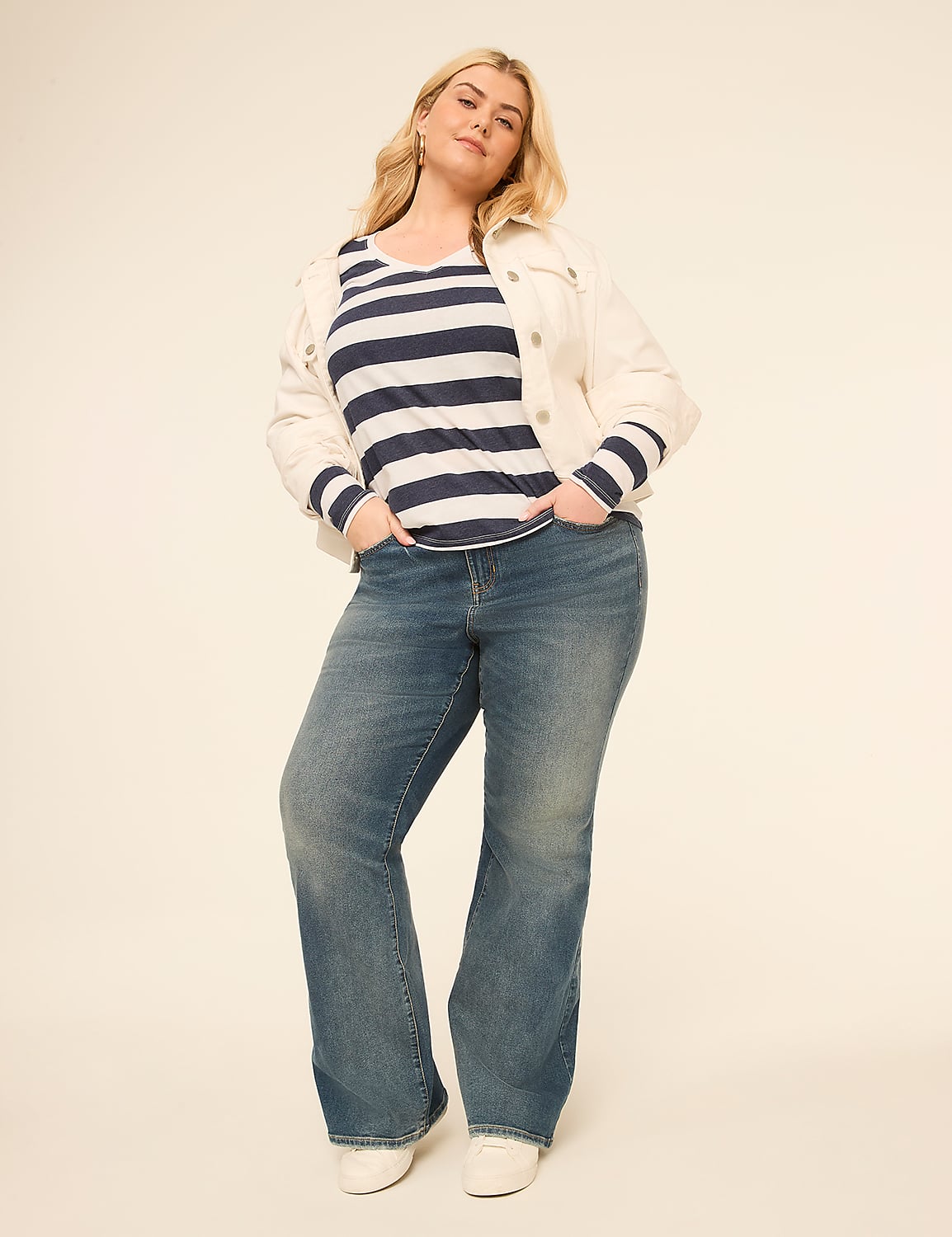 A woman in a striped shirt, white jacket, and flared jeans stands with her hands in her pockets against a plain, light-colored background. Product Image 3