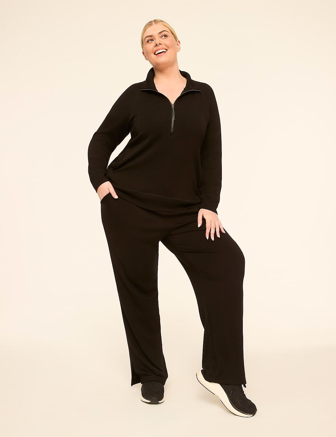 A smiling woman in a black loungewear set stands against a plain, light-colored background. Product Image 3