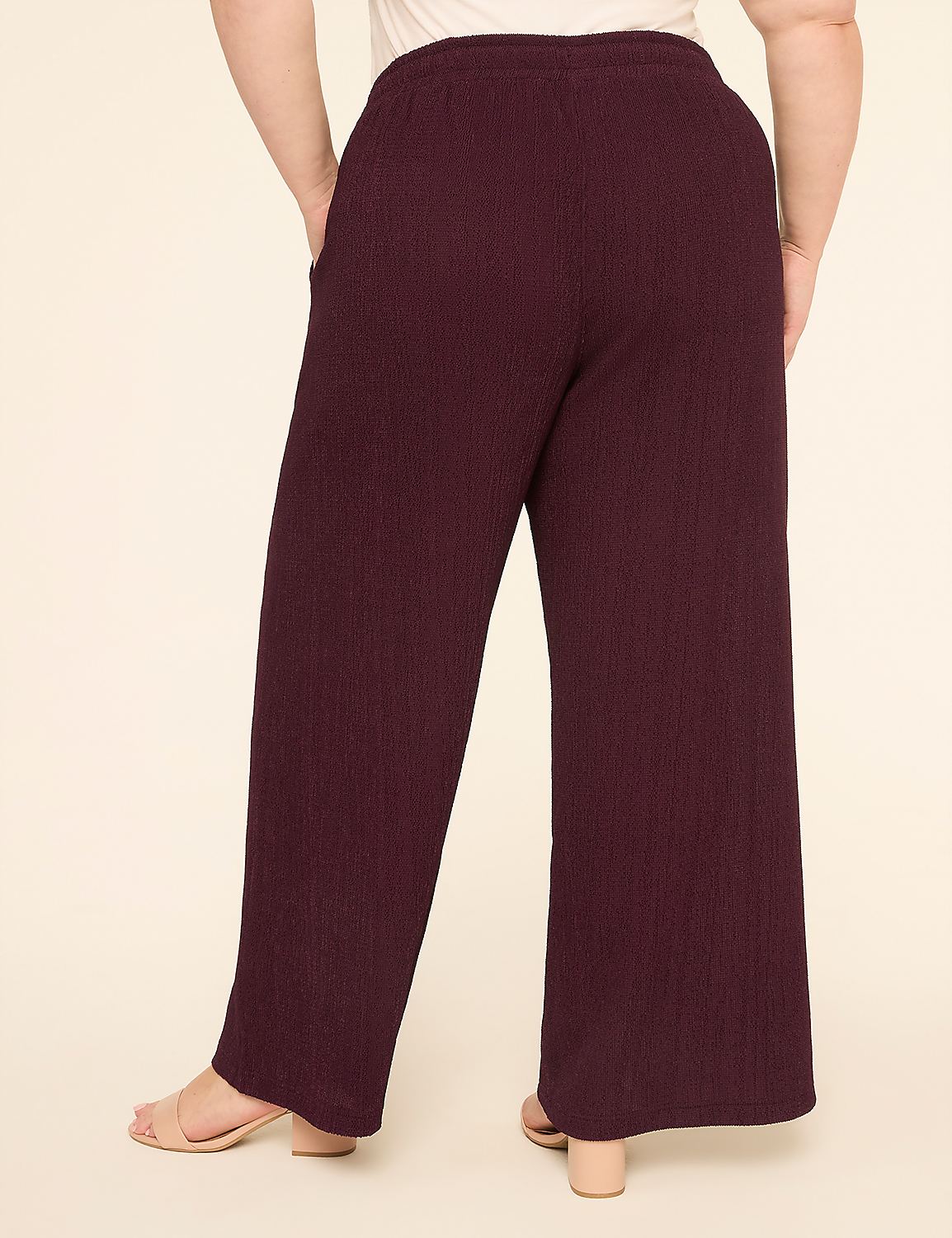 A person wearing burgundy ribbed wide-leg pants stands with their back to the camera against a plain cream background. Product Image 2